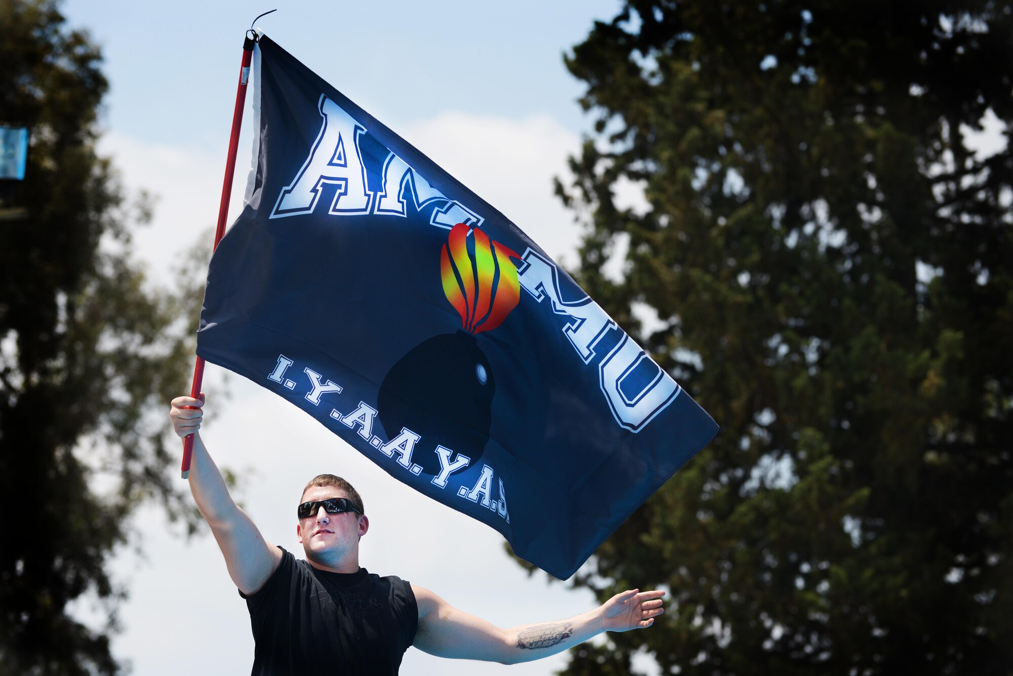 Staff Sgt. Corey Sjolander, 39th Maintenance Squadron electrical storage crew chief, waves a flag before a boat race May 31, 2014, Incirlik Air Base, Turkey. Airmen from the 39th MXS units constructed cardboard boats and raced against each other at the base pool. (U.S. Air Force photo by Senior Airman Nicole Sikorski/Released) 