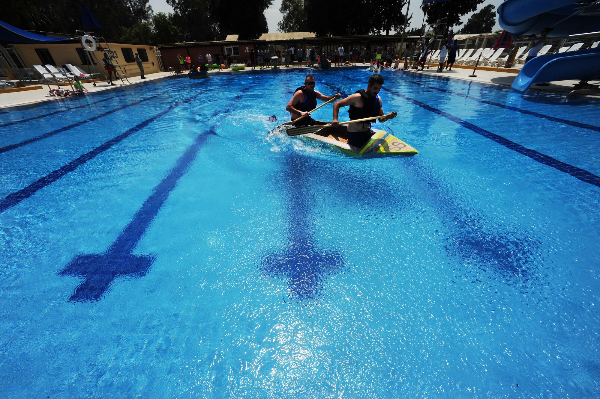 Master Sgt. Robert Dean, 39th Maintenance Squadron production superintendent and Burak Asikbekiroglu 39th MXS facility manager, race in a cardboard regatta May 29, 2014, Incirlik Air Base, Turkey.  Airmen from the 39th MXS gathered at the base pool for the annual event. (U.S. Air Force photo by Senior Airman Nicole Sikorski/Released) 