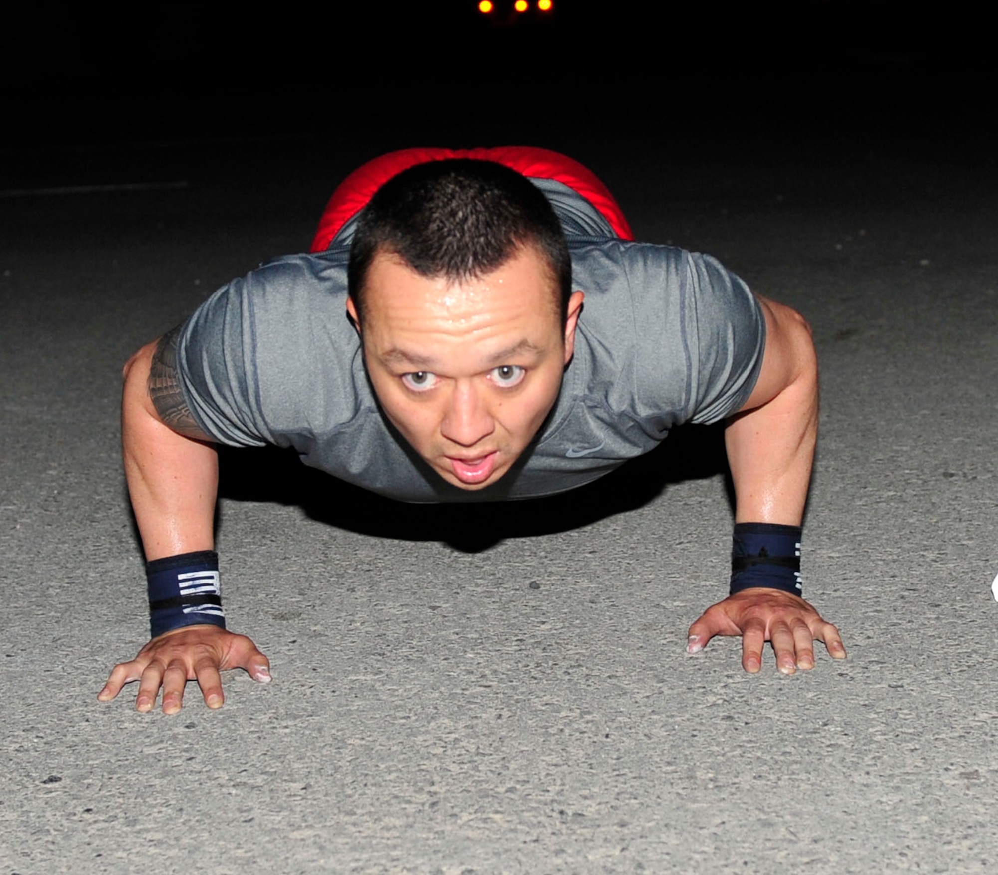 U.S. Air Force Capt. Tito Ruiz, 379th Expeditionary Security Forces Squadron operations officer, completes a pushup during a CrossFit workout session at Al Udeid Air Base, Qatar, May 21, 2014. Workouts of the day are designed to meet the CrossFit definition of constantly varied, high-intensity, functional movements performed in broad varied time domains. Ruiz’s hometown is Elizabeth City, North Carolina. (U.S. Air Force photo by Senior Airman Colin Cates) 