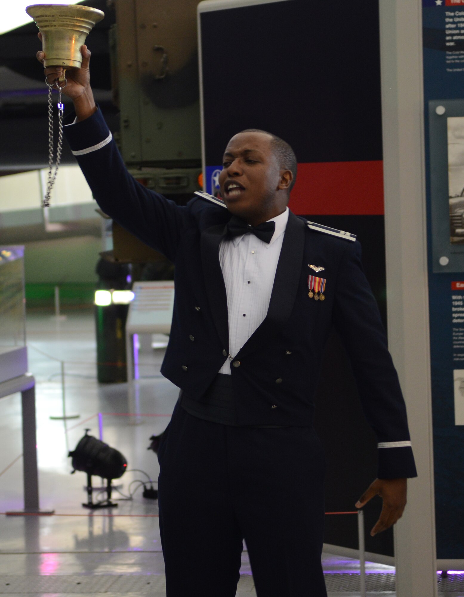 U.S. Air Force Capt. Brandon Williams, 7th Special Operations Squadron electronic warfare officer, recounts the “Story of the Bell” May 31, 2014, during the 7th SOS 50th anniversary celebration at the Imperial War Museum Duxford in Cambridge, England. The bell is part of a tradition spanning through the squadron’s history in which the youngest officer in the squadron is the keeper of the bell and must ensure its safety. (U.S. Air Force photo/Airman 1st Class Dillon Johnston/Released)