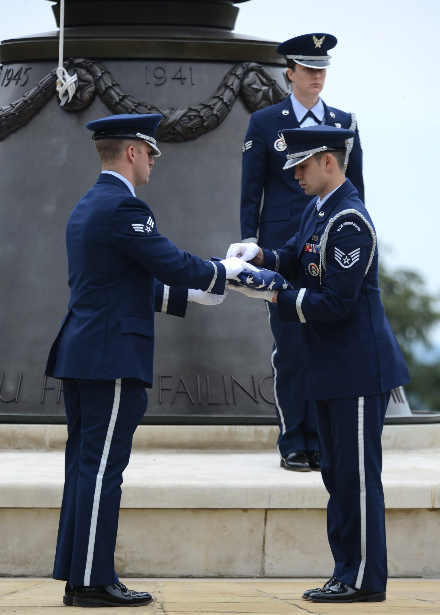 Team Mildenhall Honor Guard members finish folding the U.S. flag May 30, 2014, during a retreat ceremony at the Madingley American Cemetery in Cambridge, England. The retreat ceremony was part of the 50th anniversary celebration for the 7th Special Operations Squadron. (U.S. Air Force photo/Airman 1st Class Dillon Johnston/Released)