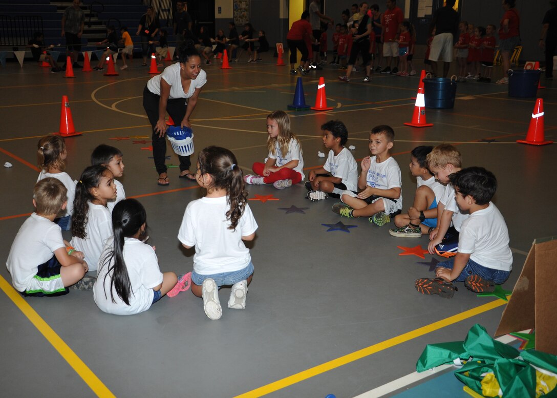 Children from Andersen Elementary School listen to a volunteer before playing a game during fitness day May 30, 2014 on Andersen Air Force Base, Guam. Fitness fun day is held once a year before students are released for summer break. (U.S. Air Force photo by Senior Airman Cierra Presentado/Released) 