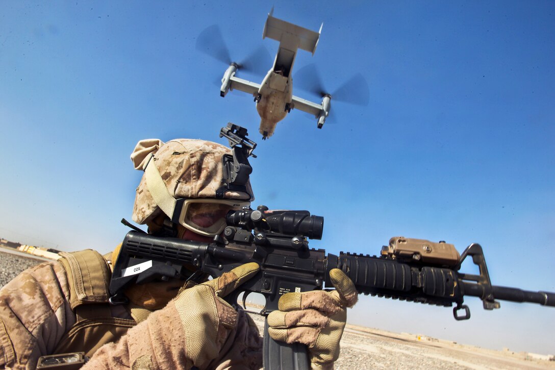 U.S. Marine Corps Cpl. William Cox provides security as an MV-22 Osprey aircraft lands in Zaranj in Afghanistan's Nimroz province, Dec. 30, 2011. Cox is an armorer assigned to the Joint Sustainment Academy Southwest.  
