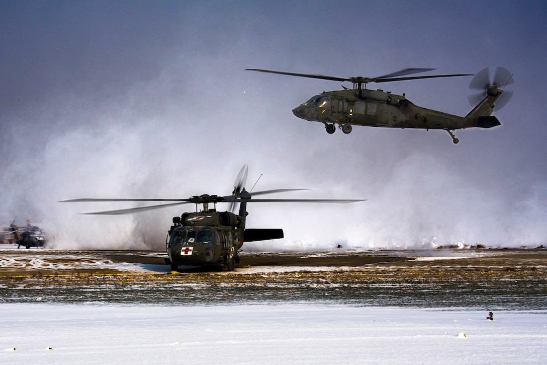 A UH-60L Black Hawk helicopter, assigned to the 1st Air Cavalry Brigade, 1st Calvary Division, takes flight, stirring up the snow as it passes over another UH-60A Black Hawk helicopter on Camp Marmal, Afghanistan, Dec. 21, 2011. The helicopters departed on a mission the morning after an overnight snowstorm.  
