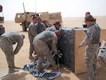 Soldiers of the 1204th Aviation Support Battalion and 1st Squadron, 7th Cavalry Regiment, recover a resupply air drop that used the Joint Precision Aerial Drop Systems near Camp Buehring, Kuwait. The JPADS were dropped from an Air Force C-17 Globemaster III aircraft as part of a training exercise in the region.