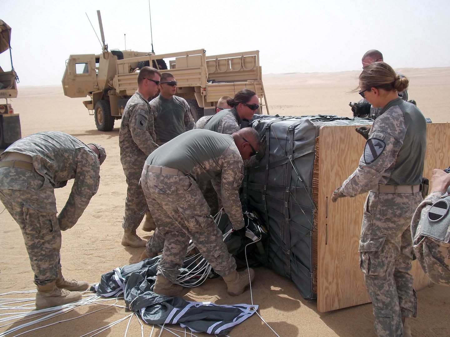 Soldiers of the 1204th Aviation Support Battalion and 1st Squadron, 7th Cavalry Regiment, recover a resupply air drop that used the Joint Precision Aerial Drop Systems near Camp Buehring, Kuwait. The JPADS were dropped from an Air Force C-17 Globemaster III aircraft as part of a training exercise in the region.