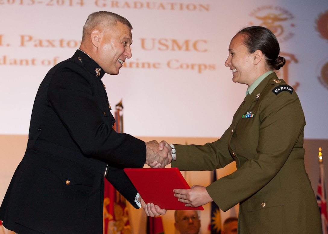 The Assistant Commandant of the Marine Corps, Gen. John M. Paxton, Jr., left, hands a diploma to a student who graduated from the Marine Corps University for the academic year of 2013-2014 at U.S. Marine Corps Base Quantico, Va., June 4, 2014. (U.S. Marine Corps by Cpl. Tia Dufour/Released)