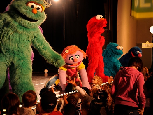 Katie, a Sesame Street character, reaches out to children in the audience during a performance May 28, 2014, at Joint Base McGuire-Dix-Lakehurst, N.J. The show was designed to shine a light on difficult situations a military child may face while allowing parents the opportunity to address stressful situations that may arise while serving in the armed forces. (U.S. Air Force photo/Staff Sgt. Scott Saldukas)