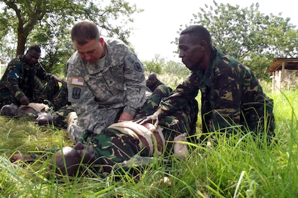 U.S. Army Staff Sgt. Miles Bizzell (left), Task Force Raptor, 3rd Squadron, 124th Cavalry Regiment, Texas Army National Guard, and Tanzanian military medical professionals exchange combat casualty care techniques, May 21 - June 8. The Texas National Guardsmen conduct various military-to-military exchanges in support of Combined Joint Task Force - Horn of Africa, whose mission is to build partnerships with nations in East Africa.