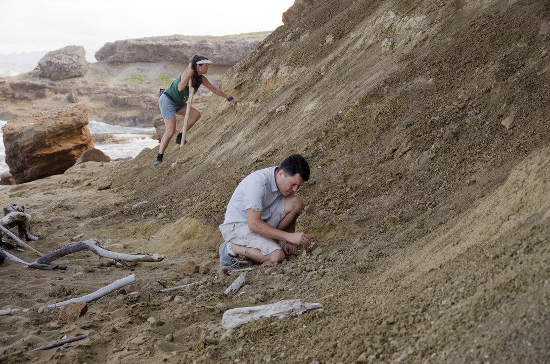 MARINE CORPS BASE HAWAII - Terry Lopez (left), a collection technician and Noa Dettweiler, the vice president and general counsel of Bishop Museum look for bird fossils at Ki’i Point Beach near Kaneohe Bay Range Training Facility aboard Marine Corps Base Hawaii, June 3, 2014. (U.S. Marine Corps photo by Kristen Wong)