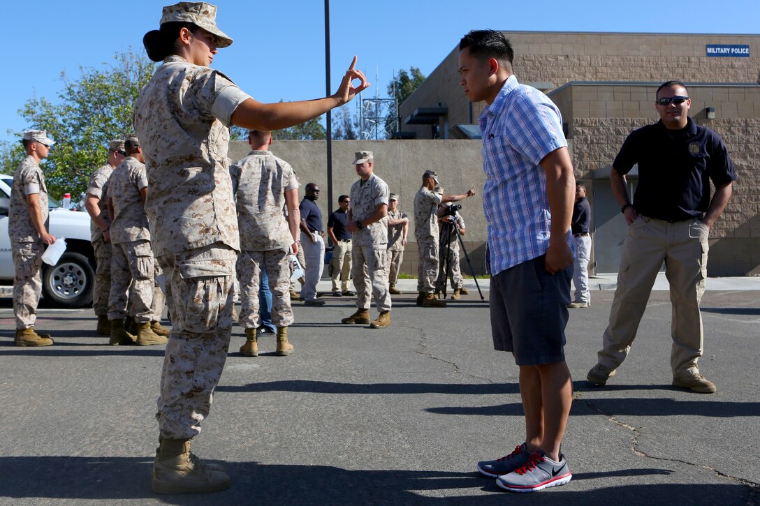 Lance Cpl. Valorie Watson, a military police officer with Headquarters and Headquarters Squadron, performs a field sobriety test on an intoxicated volunteer during driving under the influence detection training aboard Marine Corps Air Station Miramar, Calif., June 4. The training was held to help the participants better understand the effects of alcohol.