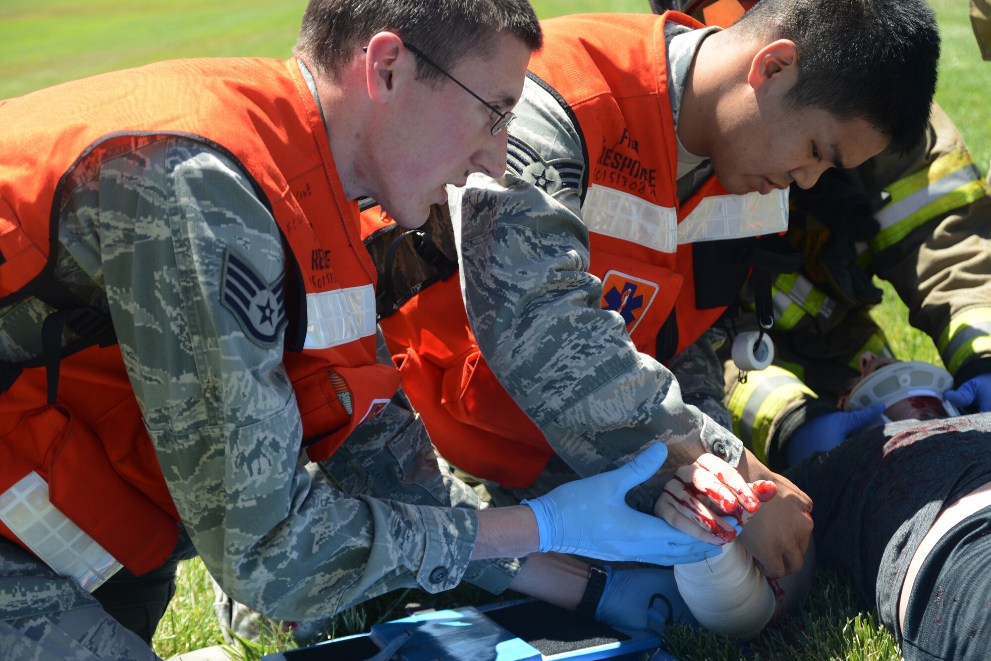 Staff Sgt. Joshua Ohlandt and Senior Airman Jonathan Balgos, 366th Medical Group first-responders, assist a moulage victim during an exercise June 4, 2014, at Mountain Home Air Force Base, Idaho. Multiple agencies participated in the training exercise which simulated a bus accident near the front gate. (U. S. Air Force photo by Senior Airman Benjamin Sutton/Released)