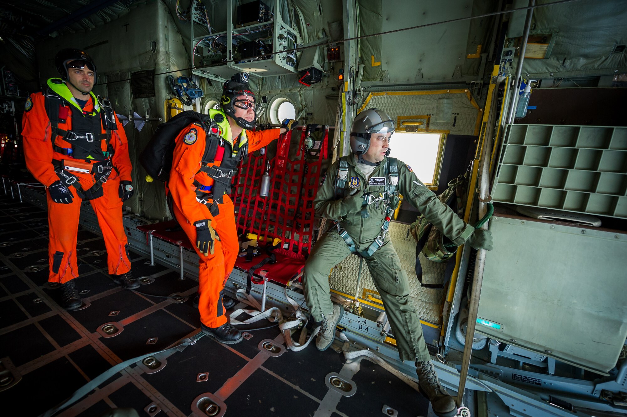 U.S. Air Force Master Sgt. Paul Serafini, C-130 loadmaster with the 914th Airlift Wing, Niagara Falls Air Reserve Station, N.Y., talks with the pilot while Royal Canadian Air Force Sgt. Glenn Hood and Master Cpl. Marc Tremblay, search and rescue technicians with the 417 Combat Support Squadron, 4 Wing Canadian Forces Base Cold Lake, Cold Lake, Alberta, Canada, await the command to jump during Maple Flag in Edmonton/Cold Lake, Alberta, Canada, June 3, 2014. Maple Flag is an international exercise designed to enhance the interoperability of C-130 aircrews, maintainers and support specialists in a simulated combat environment. (U.S. Air Force photo by Master Sgt. John R. Nimmo, Sr./Released)