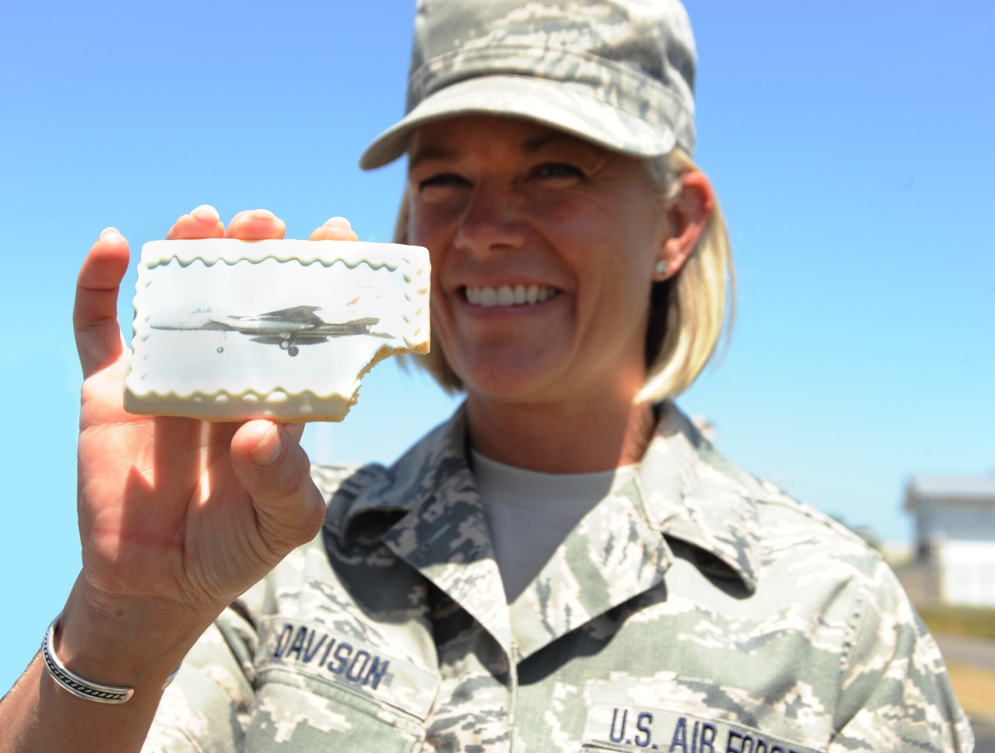 Master Sgt. Shelly Davison, assigned to the 142nd Fighter Wing Public Affairs Office, shows off a cookie after the official opening of the new Portland Air National Guard Base Service Station, June 5, 2014. (Air National Guard photo by Tech. Sgt. John Hughel, 142nd Fighter Wing Public Affairs/Released)