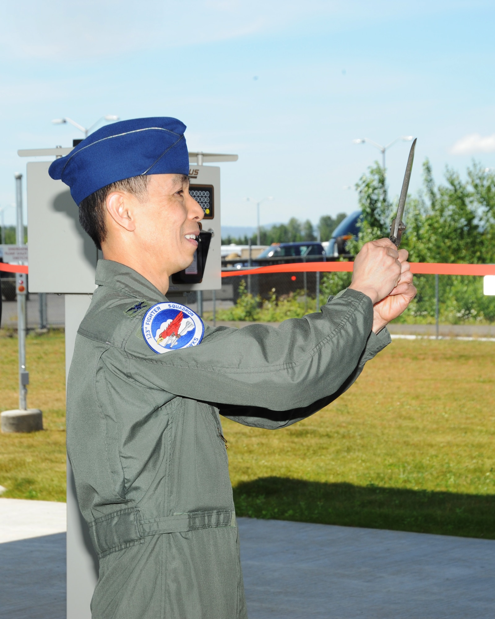 Col. Jeff Hwang, 142nd Fighter Wing Vice Commander, cuts the tape to officially open the new base Service Station, June 5, 2014 at the Portland Air National Guard Base.  (Air National Guard photo by Tech. Sgt. John Hughel, 142nd Fighter Wing Public Affairs/Released)