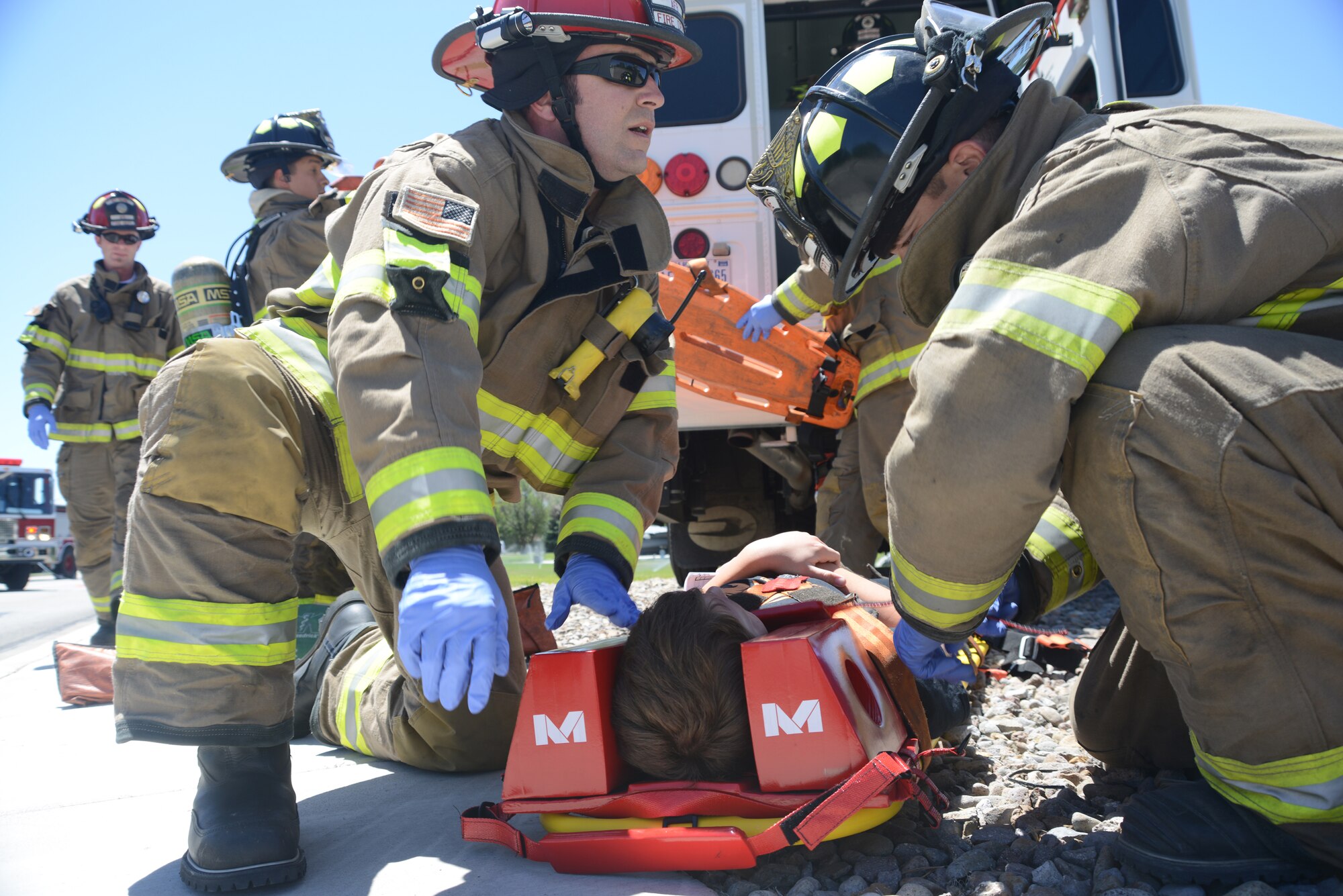 Firefighters from the 366th Civil Engineering Squadron remove a child from a bus exercise "accident" June 4, 2014, at Mountain Home Air Force Base, Idaho. The 366th Mission Support and Medical Groups worked together during the exercise in order to be better prepared in case of a real-world incident. (U. S. Air Force photo by Senior Airman Benjamin Sutton/Released) 