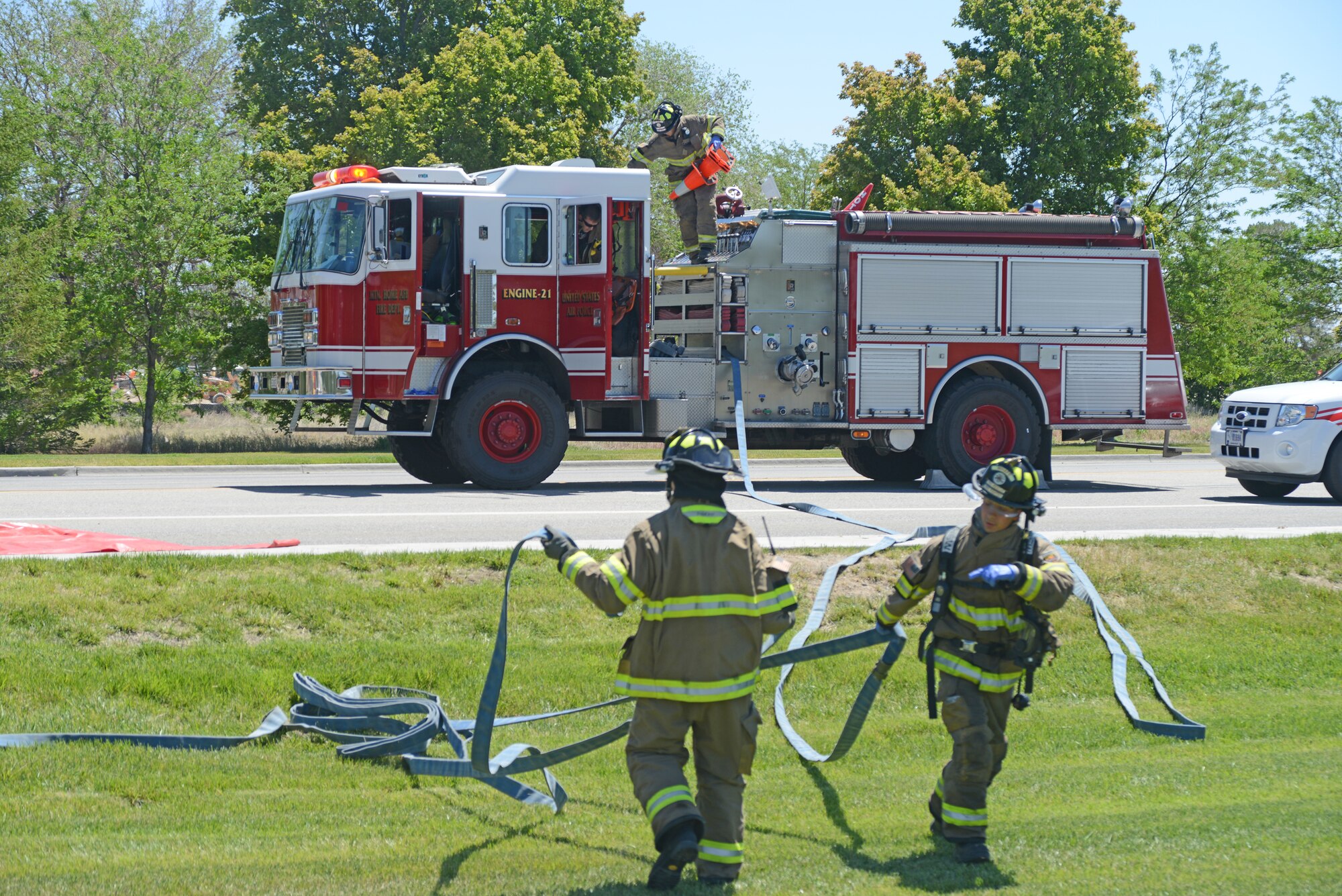 Firefighters from the 366th Civil Engineering Squadron remove a hose to put out a simulated fire during an exercise June 4, 2014, at Mountain Home Air Force Base, Idaho. More than 10 firefighter responded to the mock-accident scene and assisted with medical care of multiple exercise moulage victims. (U. S. Air Force photo by Senior Airman Benjamin Sutton/Released)