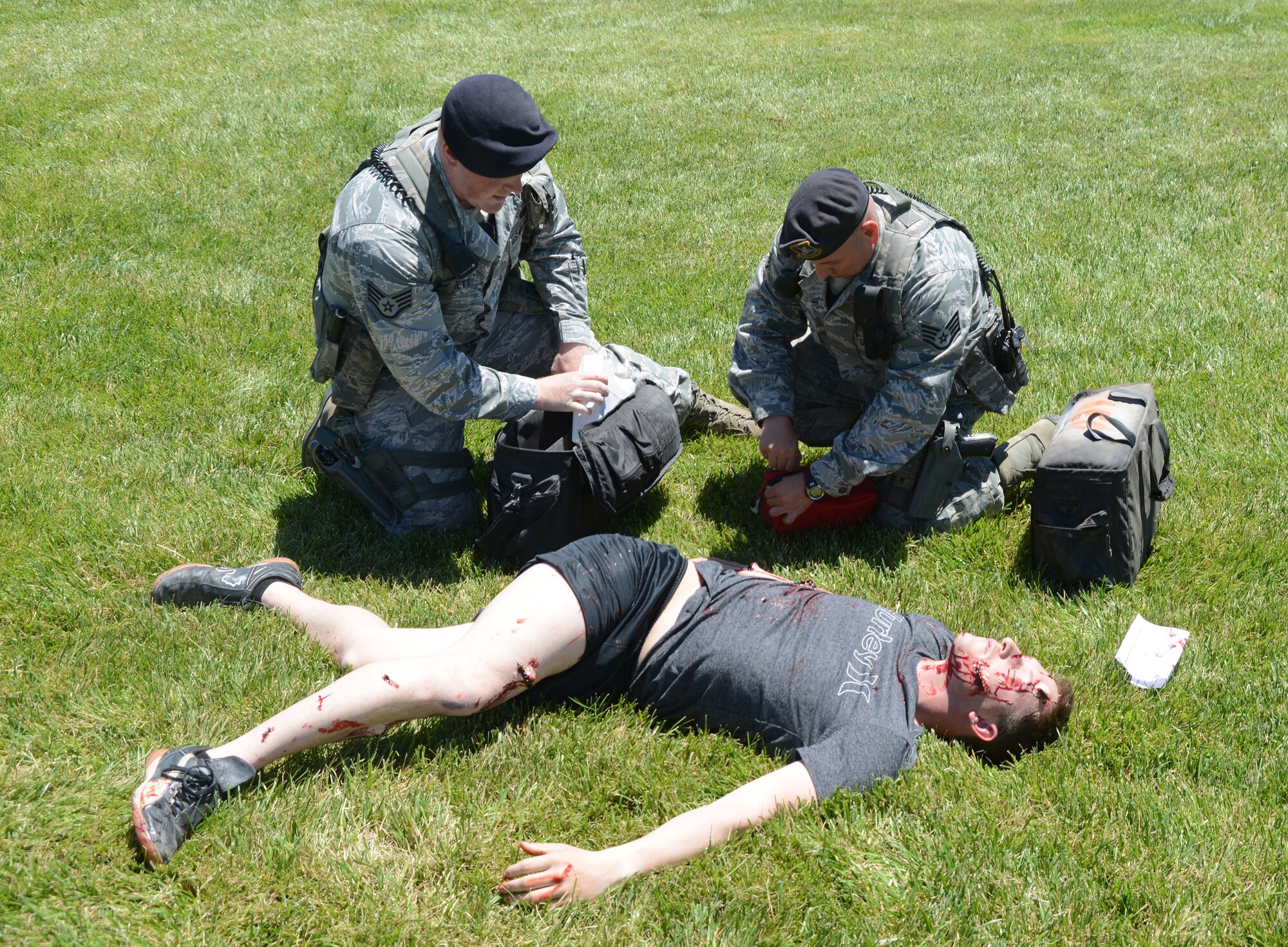 Staff Sgt. Kristopher Patchett and Staff Sgt. Roland Quick, both 366th Security Forces Squadron patrolmen, perform self-air buddy care on an exercise victim June 4, 2014, at Mountain Home Air Force Base, Idaho. Patchett and Quick were some of the first Airmen on the mock-scene and assisted with medical care as well as performing area security throughout the entirity of the exercise. (U. S. Air Force photo by Senior Airman Benjamin Sutton/Released)