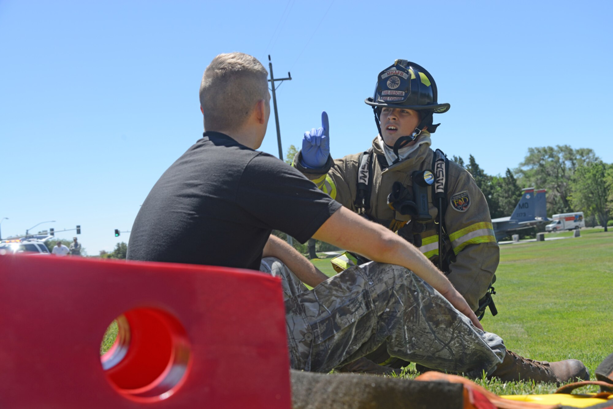Airman 1st Class Eric Hunt, 366th Civil Engineering Squadron firefighter, performs a basic eye movement test on an exercise victim with a fake moulage wound June 4, 2014, at Mountain Home Air Force Base, Idaho. The 366th Mission Support Group teamed up with the 366th Medical Group for the impromptu exercise in order to evaluate base first-responders. (U. S. Air Force photo by Senior Airman Benjamin Sutton/Released)