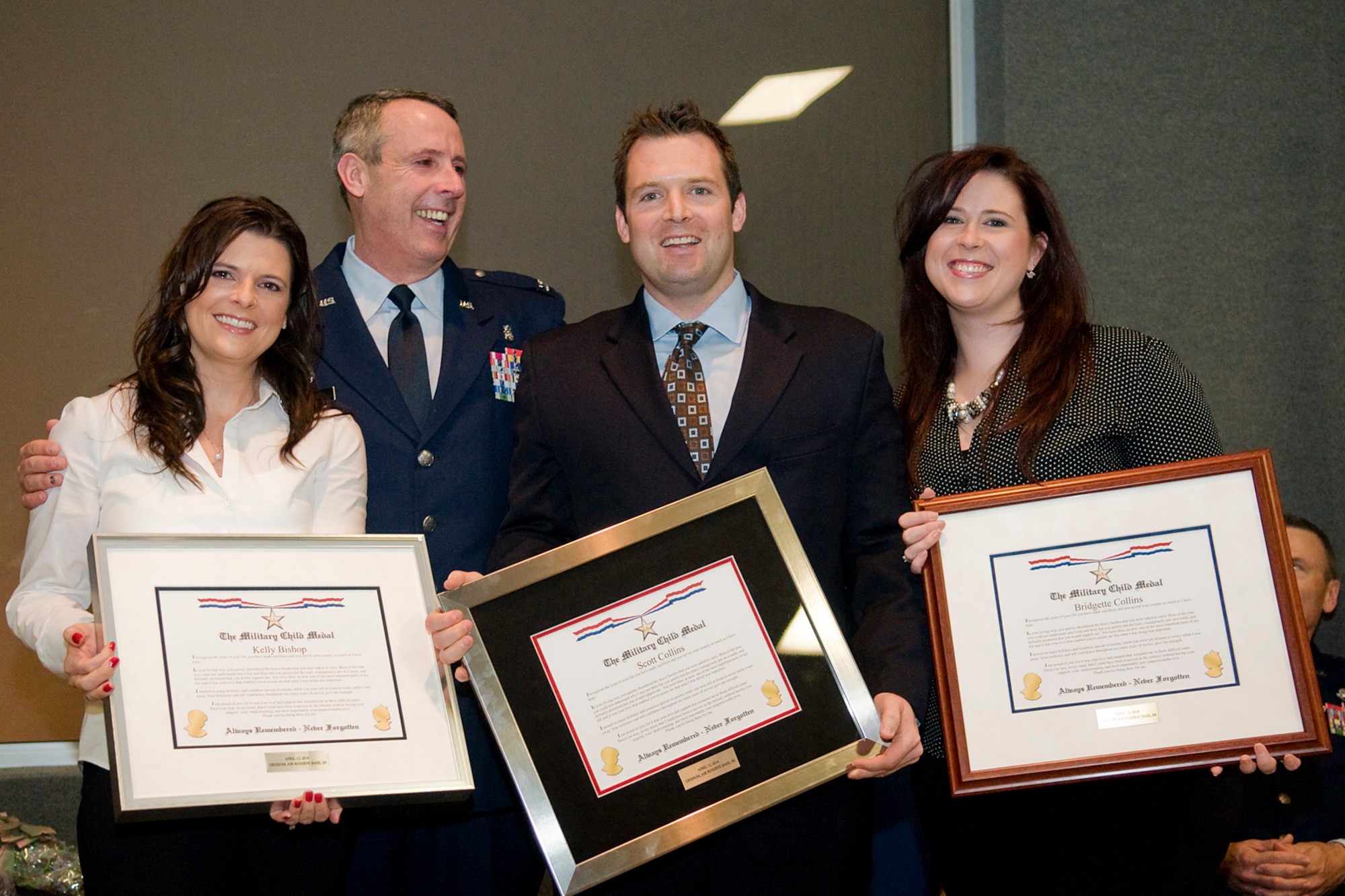 Col. Thomas Collins, 434th Aerospace Medicine Squadron commander, presents his children, Kelly Bison, Scott Collins and Bridgette Collins, with military child medals during his retirement ceremony at Grissom Air Reserve Base, Ind., April 13, 2014. Collins retired after serving nearly 38 years in both the regular Air Force and Air Force Reserve. (U.S. Air Force photo/Tech. Sgt. Mark R. W. Orders-Woempner) 
