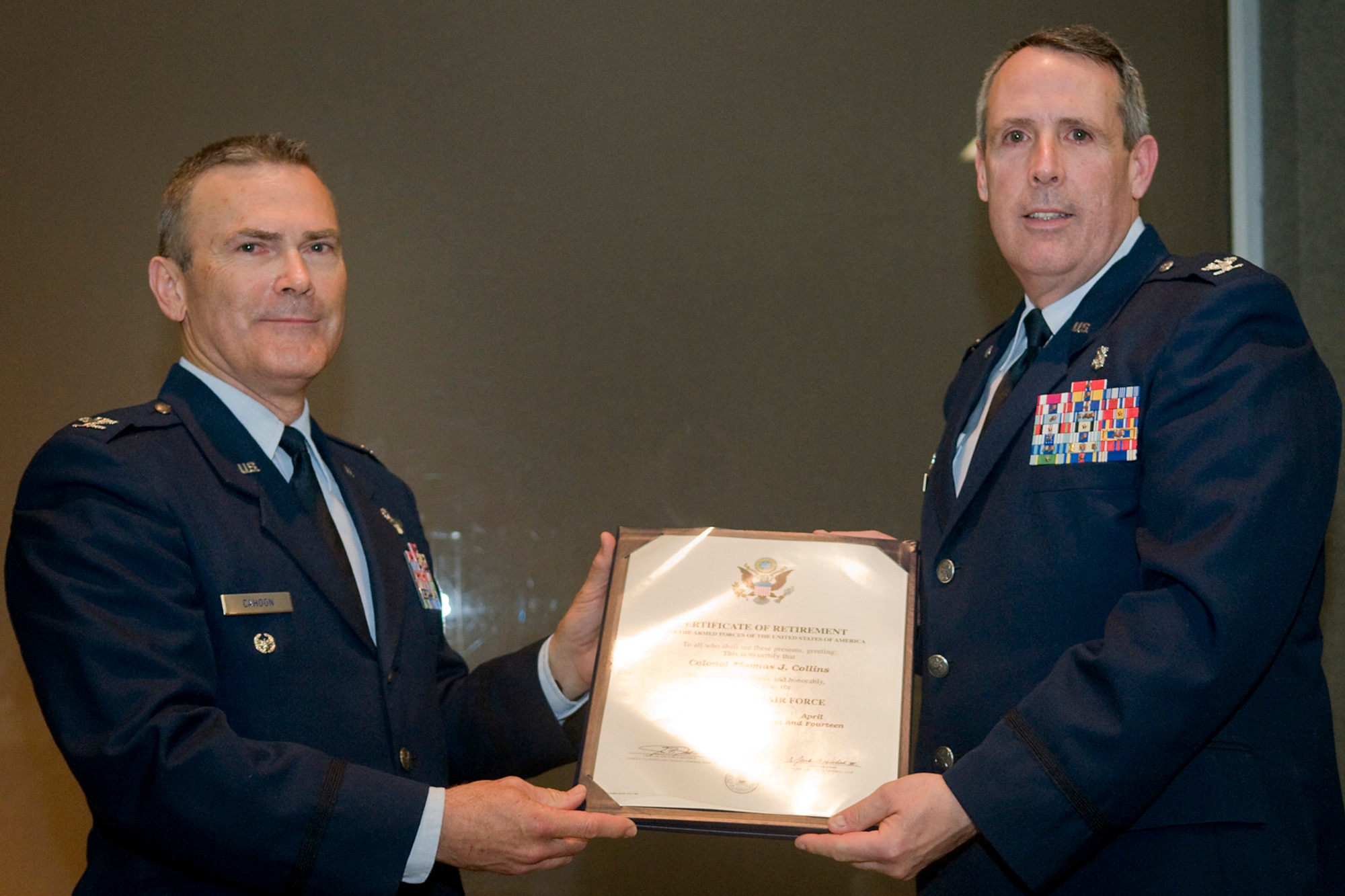 Retired Col. William Cahoon, a previous 434th Air Refueling Wing commander, presents Col. Thomas Collins, 434th Aerospace Medicine Squadron commander, with a certificate of retirement at Grissom Air Reserve Base, Ind., April 13, 2014. Collins retired after serving nearly 38 years in both the regular Air Force and Air Force Reserve. (U.S. Air Force photo/Tech. Sgt. Mark R. W. Orders-Woempner)
