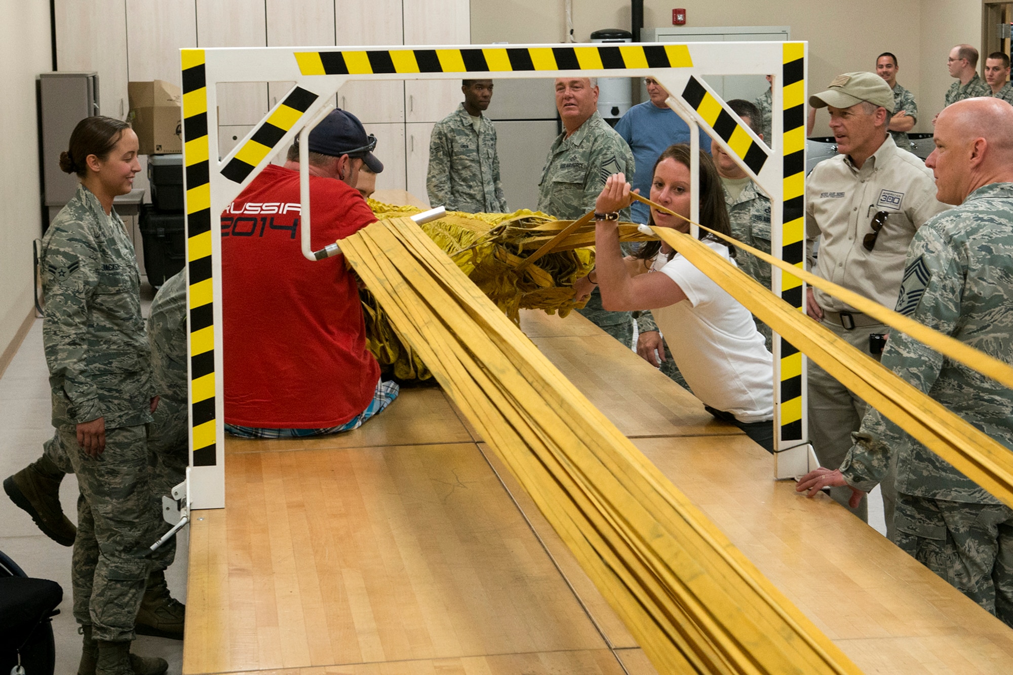 Emily Cook, 3-time Olympian U.S. Freestyle skier, and Patrick McDonald, U.S. Paralympic Curling Team captain, help repack a B-52H Stratofortress drag chute chute during a tour of the 307th Operations Support Flight aircrew flight equipment shot, June 4, 2014, Barksdale Air Force Base, La. Cook and McDonald are part of the American300 Tours, which visits military installations with the goal of increasing resiliency of the troops, their families, and the communities that they live and operate in. (U.S. Air Force photo by Master Sgt. Greg Steele/Released)
