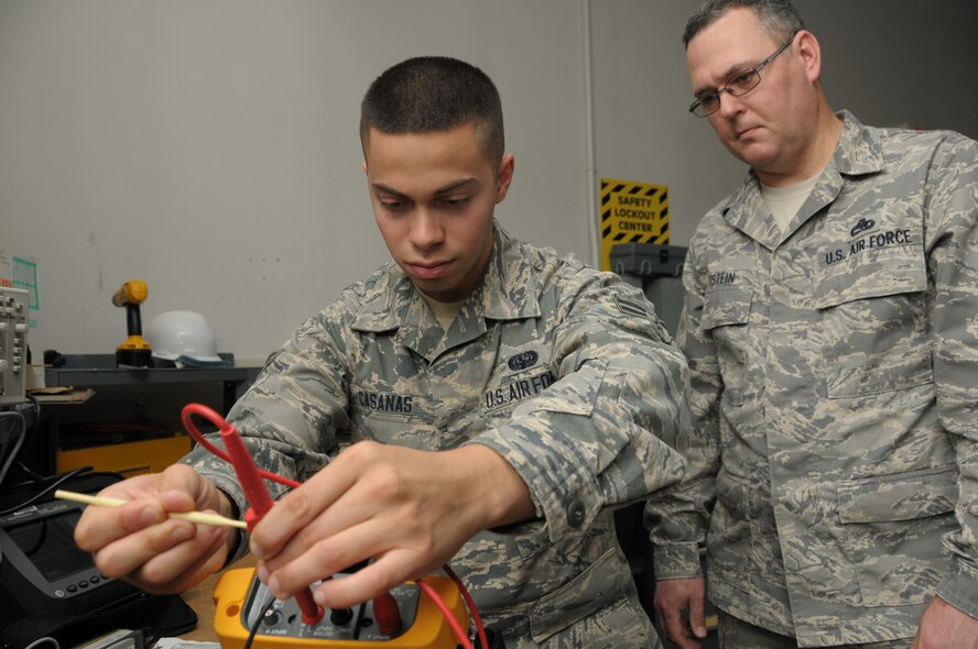 PEASE AIR NATIONAL GUARD BASE, N.H. -- Airman 1st Class Abdiel Casanas, 260th Air Traffic Control Squadron airfield systems technician, under the watchful eye of his supervisor, Master Sgt. Michael C. Wettstein, works on a piece of equipment at the squadron during drill last month. Casanas leaves in early July to attend the U.S. Air Force Academy Prep School in Colorado. (N.H. Air National Guard photo by Staff Sgt. Curt Lenz/RELEASED)
