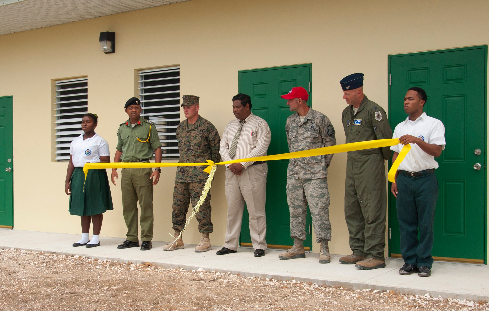 One each end, an Edward P. Yorke student holds a yellow ribbon as, from left, Belize Defence Force Gen. David Jones, BDF commander, U.S. Marine Corps Staff Sgt. Matt Houle, construction site foreman, Rodrick Cardinez, E.P. Yorke principal, U.S. Air Force Master Sgt. Nicholas Alessi, construction site project manager, and U.S. Air Force Col. Dan Pepper, New Horizons Task Force commander, participate in the ribbon cutting ceremony at the school June 4, 2014, in Belize City, Belize. The school's 1,372 square foot, two-classroom addition is one of five New Horizons projects in the country. New Horizons is an annual multinational exercise that provides training opportunities in civil engineering and medical care. (U.S. Air Force photo by Tech. Sgt. Kali L. Gradishar/Released)