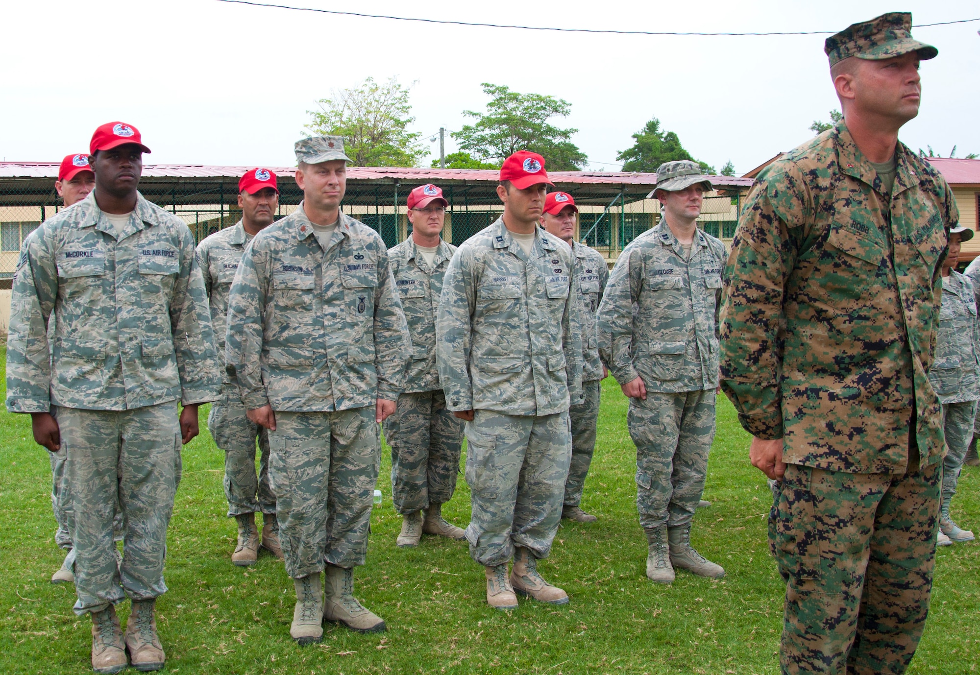 U.S. Marine Corps Chief Warrant Officer Patrick Robb, officer in charge of New Horizons Marine Corps engineers, right, leads a formation during a ribbon cutting ceremony June 4, 2014, at the school in Belize City, Belize. Marines from various Marine Wing Support Squadrons under the 4th Marine Aircraft Wing worked with engineers from the Belize Defence Force, U.S. Air Force and U.S. Army for nearly 40 working days to build the school's 1,372 square foot, two-classroom. New Horizons is an annual multinational exercise that provides training opportunities in civil engineering and medical care. (U.S. Air Force photo by Tech. Sgt. Kali L. Gradishar/Released)
