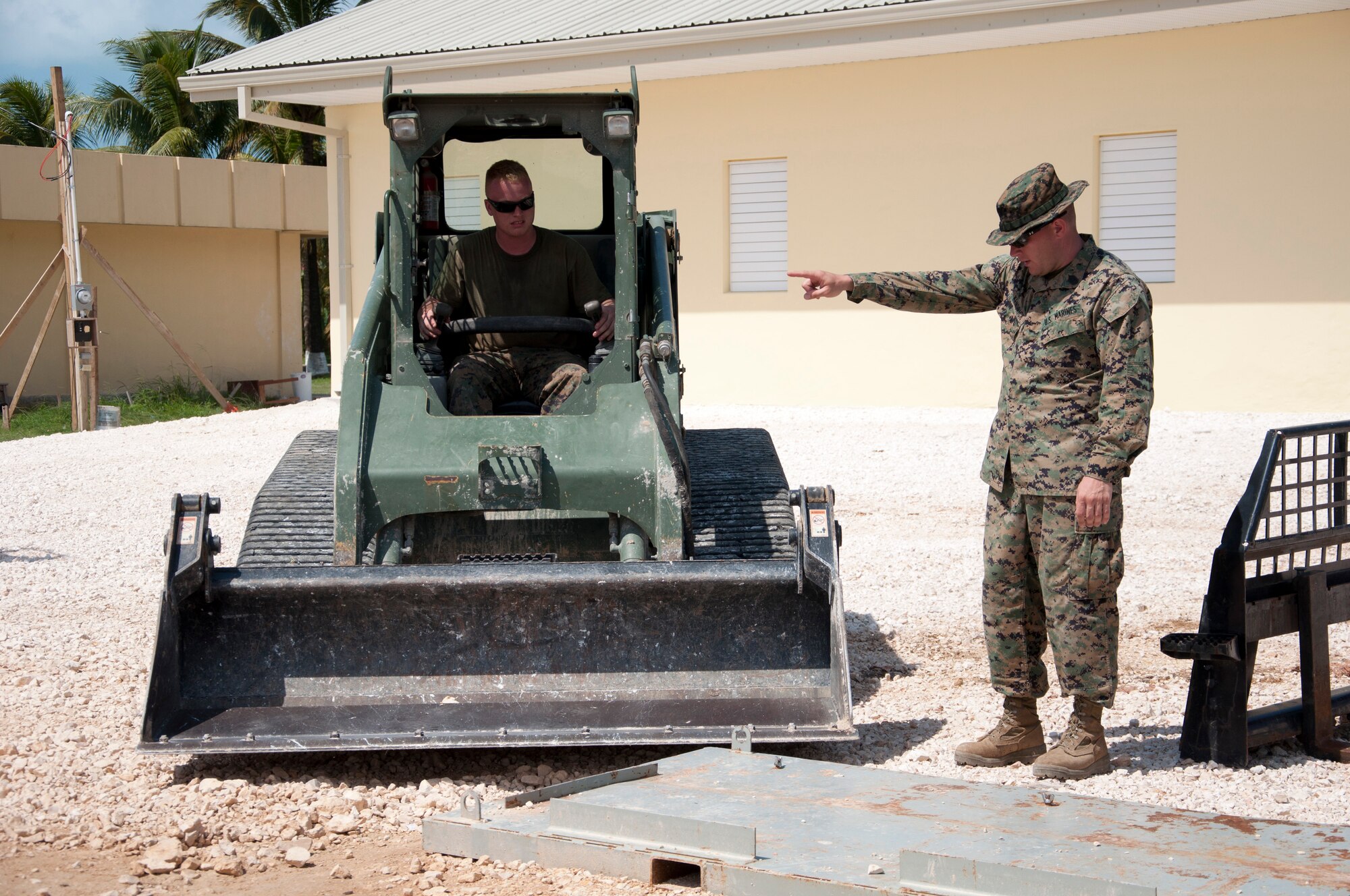 U.S. Marine Corps Gunnery Sgt. Robert Kendrick, Marine Wing Support Squadron 471, right, directs U.S. Marine Corps Lance Cpl. Dylan Secoy, Marine Wing Support Squadron 472, during the clean-up phase of construction at the Edward P. Yorke school construction site May 28, 2014, in Belize City, Belize. Marines from various Marine Wing Support Squadrons under the 4th Marine Aircraft Wing worked with engineers from the Belize Defence Force, U.S. Air Force and U.S. Army for nearly 40 working days to build two additional classrooms for the school as part of New Horizons Belize 2014. New Horizons is a multinational exercise that offers training and advancement opportunities in the civil engineering and medical fields. The mainly Marine-built addition to the E.P. Yorke school was officially handed over to the school principal June 4, 2014. (U.S. Air Force photo by Tech. Sgt. Kali L. Gradishar/Released)