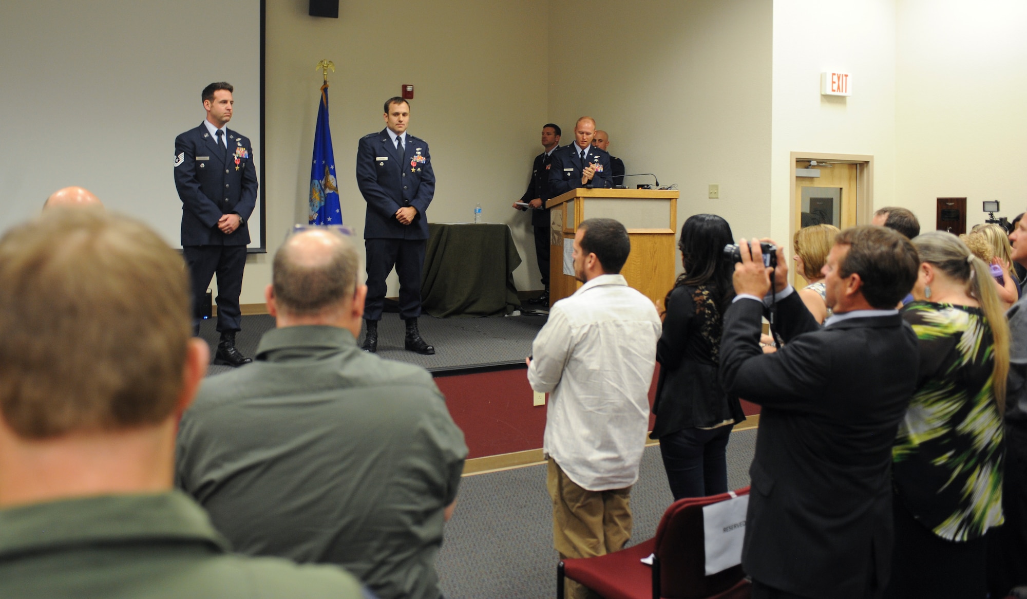 U.S. Air Force Capt. Kevin Epstein, 48th Rescue Squadron combat rescue officer, and Tech. Sgt. Brandon Daugherty, 306th Rescue Squadron pararescueman, receive a standing ovation during a Bronze Star presentation at Davis-Monthan Air Force Base, Ariz., June 2, 2014. During their deployment in Afghanistan, Epstein and Daugherty risked their lives in order to save a Marine’s life. (U.S. Air Force photo by Senior Airman Sivan Veazie/Released)