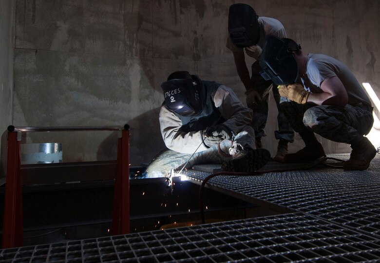 HAROLD E. HOLT NAVAL COMMUNICATION STATION, Australia -- Tech Sgt. Mark Smith, structures supervisor for the Alaska Air National Guard's 176th Civil Engineering Squadron, demonstrates welding techniques to two junior Airmen here May 6, 2014. The three were among 34 Guard members deployed here for three weeks to prepare the site to receive a space radar antenna being relocated from the Caribbean Island of Antigua. National Guard photo by Capt. John Callahan