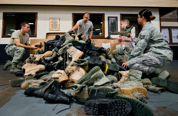 Senior Airman Cameron Gnile, Airmen 1st Class Sia Pocholo, Timothy Burd and Tech. Sgt. Ana Silva, of the 96th Logistics Readiness Squadron, gather up more than 375 donated military boots for the “Boots on the Ground” traveling memorial June 4 at Eglin Air Force Base, Fla.  Silva led others from seven units throughout the base to get the word out and collect the boots for the cause.  After collecting, counting and boxing up the boots, Silva delivered them to the drop-off point at Fort Benning, Ga., June 7.  The boots will be placed in long lines with an American Flag and a picture of a first responder/service member who died after 9/11.  (U.S. Air Force photo/Samuel King Jr.)