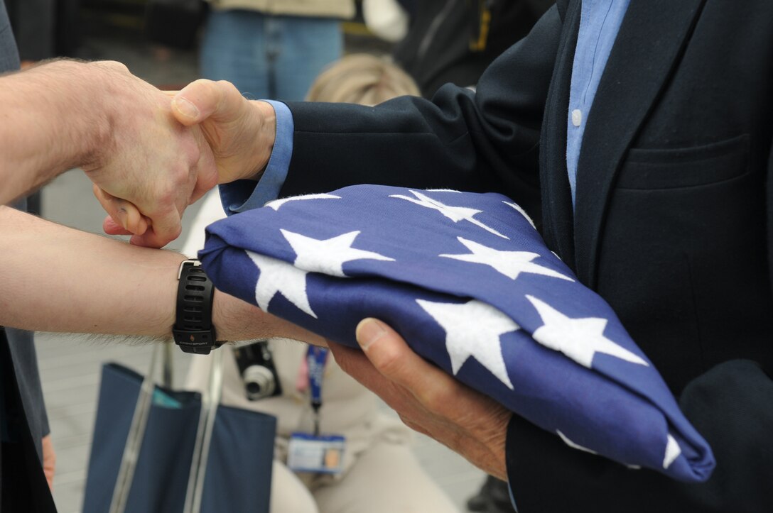 An American flag is presented to a D-Day veteran before he departs on a journey from Portsmouth, United Kingdom to Normandy to commemorate the 70th anniversary of the D-Day landings, June 3, 2014. The 422nd and 423rd Air Base Groups Honor Guard members of the 501st Combat Support Wing showed their respect and helped kick-off the veteran’s journey. (U.S. Air Force photo by Tech. Sgt. Chrissy Best) 

