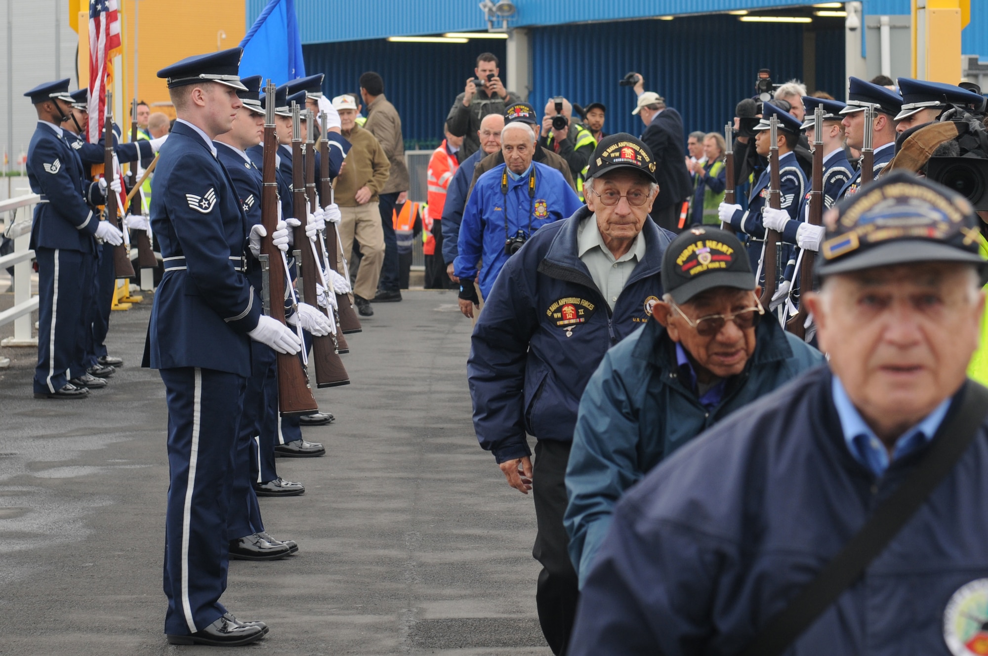 D-Day veterans, who traveled from the United States to the England, march through two lines of riflemen as a ceremonial salute is rendered in their honor at Portsmouth, United Kingdom, June 3, 2014. The 422nd and 423rd Air Base Groups Honor Guard members of the 501st Combat Support Wing showed their respect and helped kick-off the veterans’ journey to Normandy to commemorate the 70th anniversary of the D-Day landings. (U.S. Air Force photo by Tech. Sgt. Chrissy Best)