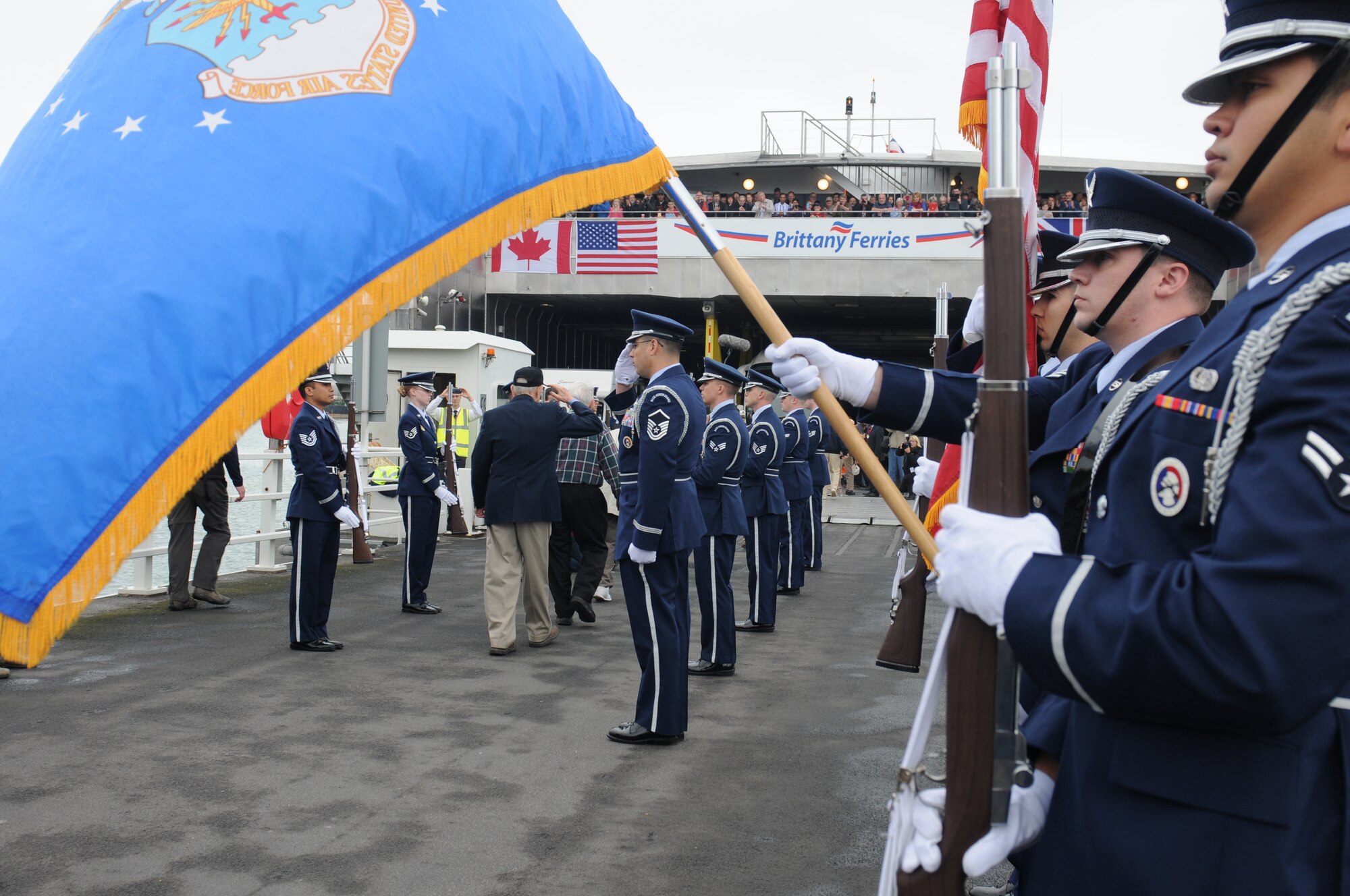 Honor Guard members from 422nd and 423rd Air Base Group of the 501st Combat Support Wing render a ceremonial salute for the U.S. D-Day veterans as they take part in the 70th anniversary of the invasion by journeying to Normandy from Portsmouth, United Kingdom, June 3, 2014. A series of events commemorating the 70th anniversary were planned for the week with many U.S. leaders travelling to the famous beaches to pay their respects to those who lost their lives. (U.S. Air Force photo by Tech. Sgt. Chrissy Best)