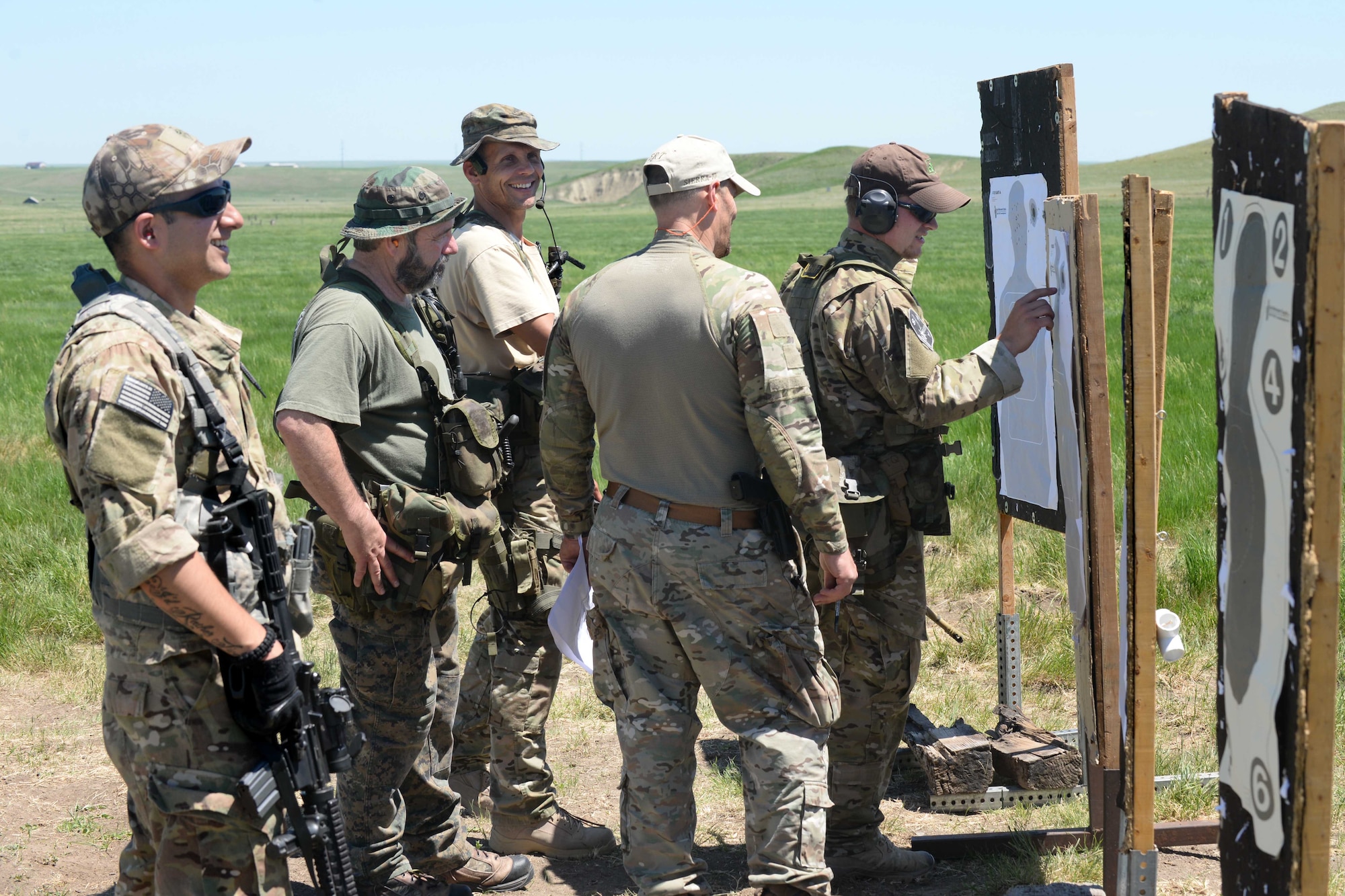 Staff Sgt. Edgar Cerrillo (left), 28th Security Forces Squadron unit orientation training instructor, checks targets with the Rapid City/Pennington County special response team members after a series of drills at an outdoor shooting range in Rapid City, S.D., May 29, 2014. Training with RC/PC SRT is beneficial to everyone involved, bringing years of experience together for enhanced interoperability. (U.S. Air Force photo by Airman 1st Class Rebecca Imwalle/ Released)