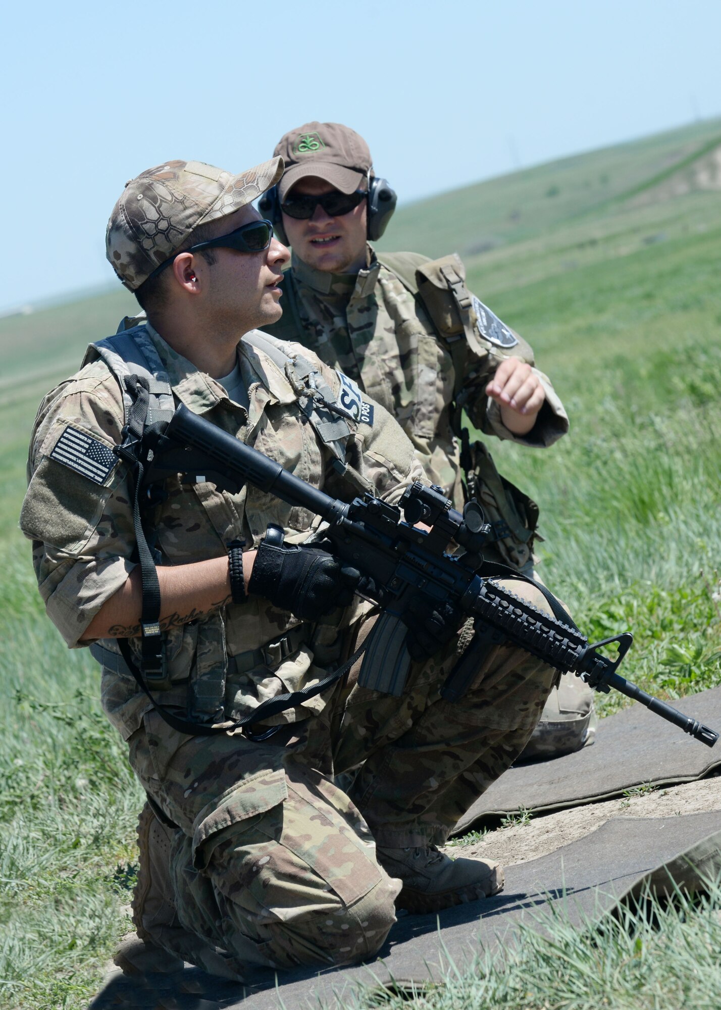 Staff Sgt. Edgar Cerrillo (left), 28th Security Forces Squadron unit orientation training instructor, works with Casey Kenrick, Pennington County sheriff investigator and a Rapid City/PC special response team member, during a training day at an outdoor shooting range in Rapid City, S.D., May 29, 2014. Training consisted of three elements; night vision familiarization, an obstacle course, and a qualification course. (U.S. Air Force photo by Airman 1st Class Rebecca Imwalle/ Released)