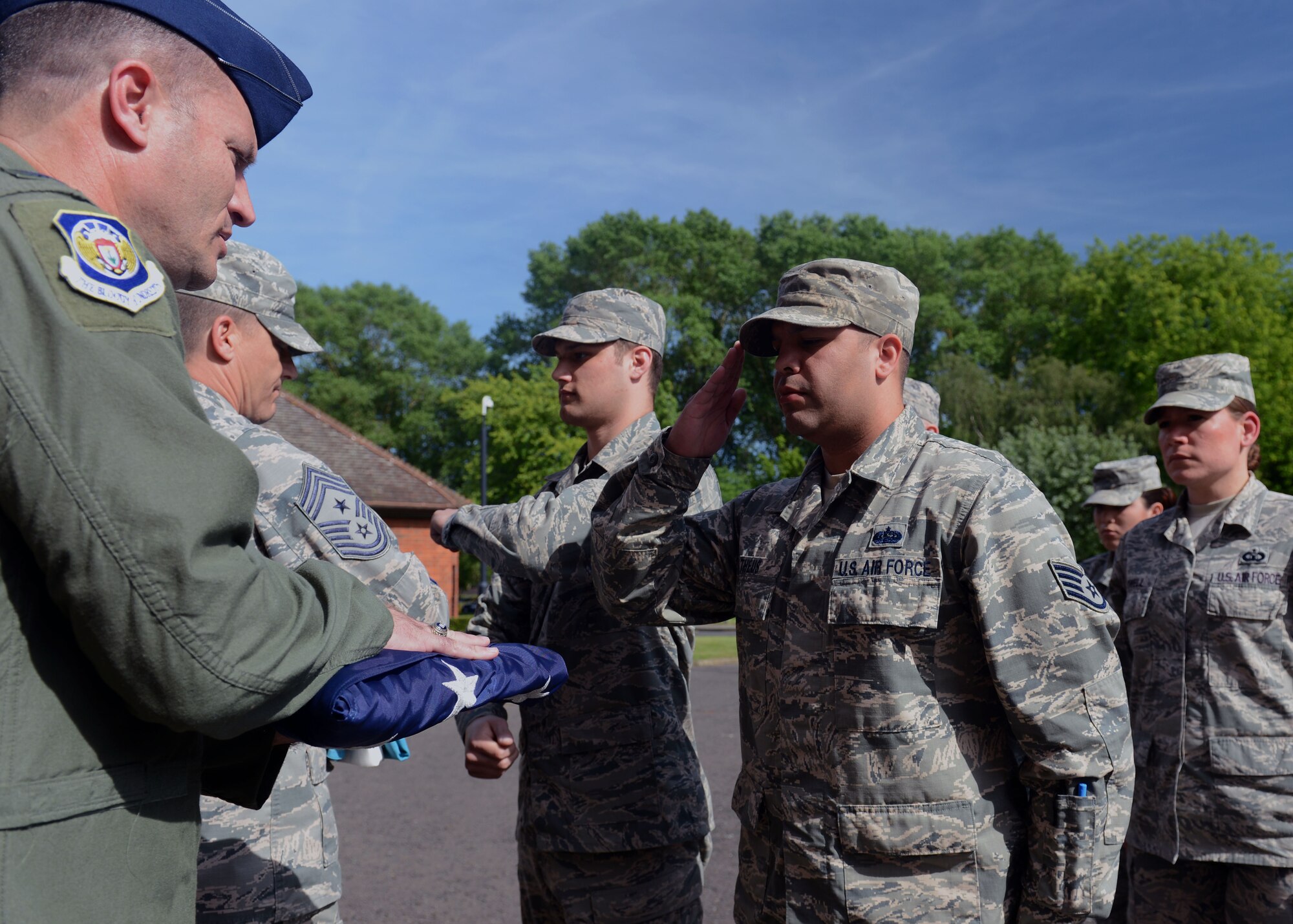 U.S. Air Force Col. Kenneth T. Bibb Jr., left, 100th Air Refueling Wing commander, receives the U.S. flag from a flag detail after a retreat ceremony June 6, 2014, on RAF Mildenhall, England. Retreat is a long-standing tradition honoring the flag at the end of the duty day. (U.S. Air Force photo/Airman 1st Class Preston Webb/Released)