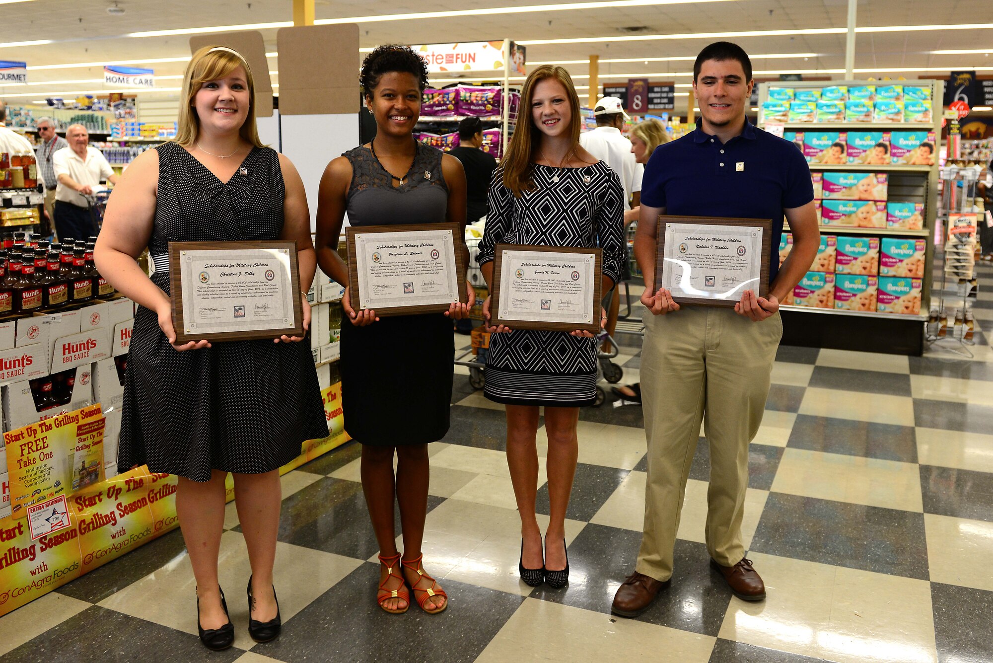 Local students receive scholarships from the Fisher House Foundation at the Commissary at Fort Eustis, Va., June 5, 2014. The Scholarships for Military Children Program was created in recognition of the contributions of military families, and the scholarships are granted through annual contributions by the Defense Commissary Agency worldwide. (U.S. Air Force photo by Airman 1st Class Kimberly Nagle/Released)