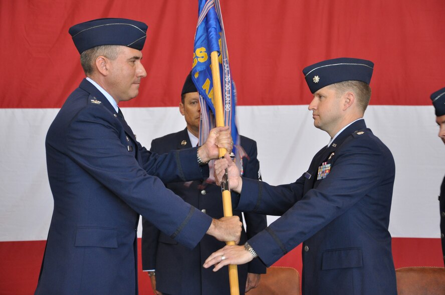 Col. John J. Cooper, 552nd Operations Group commander, left, passes the guidon to Lt. Col. Marc A. Langohr, right, signaling Colonel Langohr’s assumption of command of the 964th Airborne Air Control Squadron from Lt. Col. Darren R. DeRoos during a traditional ceremony held Thursday, May 29 in Bldg. 230, Dock 2, before a host of friends, family and fellow service members. Colonel Langohr previously served as director of Operations for the 960th AACS. Colonel DeRoos will now become deputy commander to Colonel Cooper, who presided over the ceremony. (Air Force photo by Darren D. Heusel)