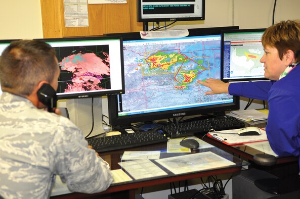 1st Lt. Casey Neuville, weather officer, and Tina Stott, weather technician, both with the 72nd Operations Support Squadron’s Weather Flight, monitor and analyze weather conditions on Tinker Air Force Base.  They keep in contact with the National Weather Service and the 26th Operational Weather Squadron to collaborate the best operational weather decisions are made. (Air Force photo by Kimberly Woodruff)