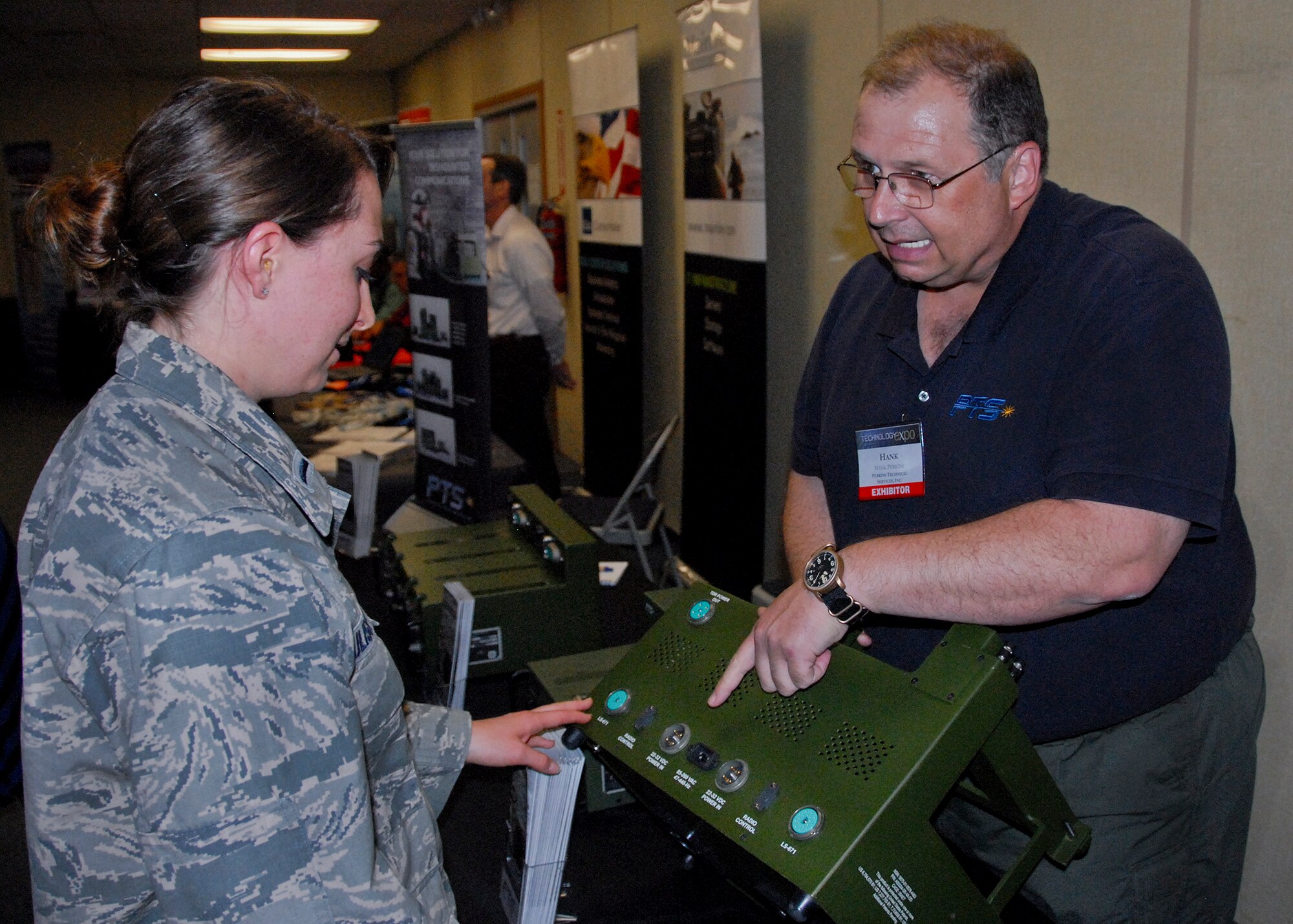 1st Lt. Morgan Ulisse, of the 96th Force Support Squadron, receives a briefing on a power supply docking station from Hank Perkins, technical director at Perkins Technical Services, a hardware and technical program support provider, at the Technology Expo, at Eglin Air Force Base, Fla. June 5.  More than 30 exhibitors from across the United States offered information and displays about the latest defense technologies; storage solutions; and logistical and engineering services, among other technologies.  (U.S. Air Force photo/Kevin Gaddie)   