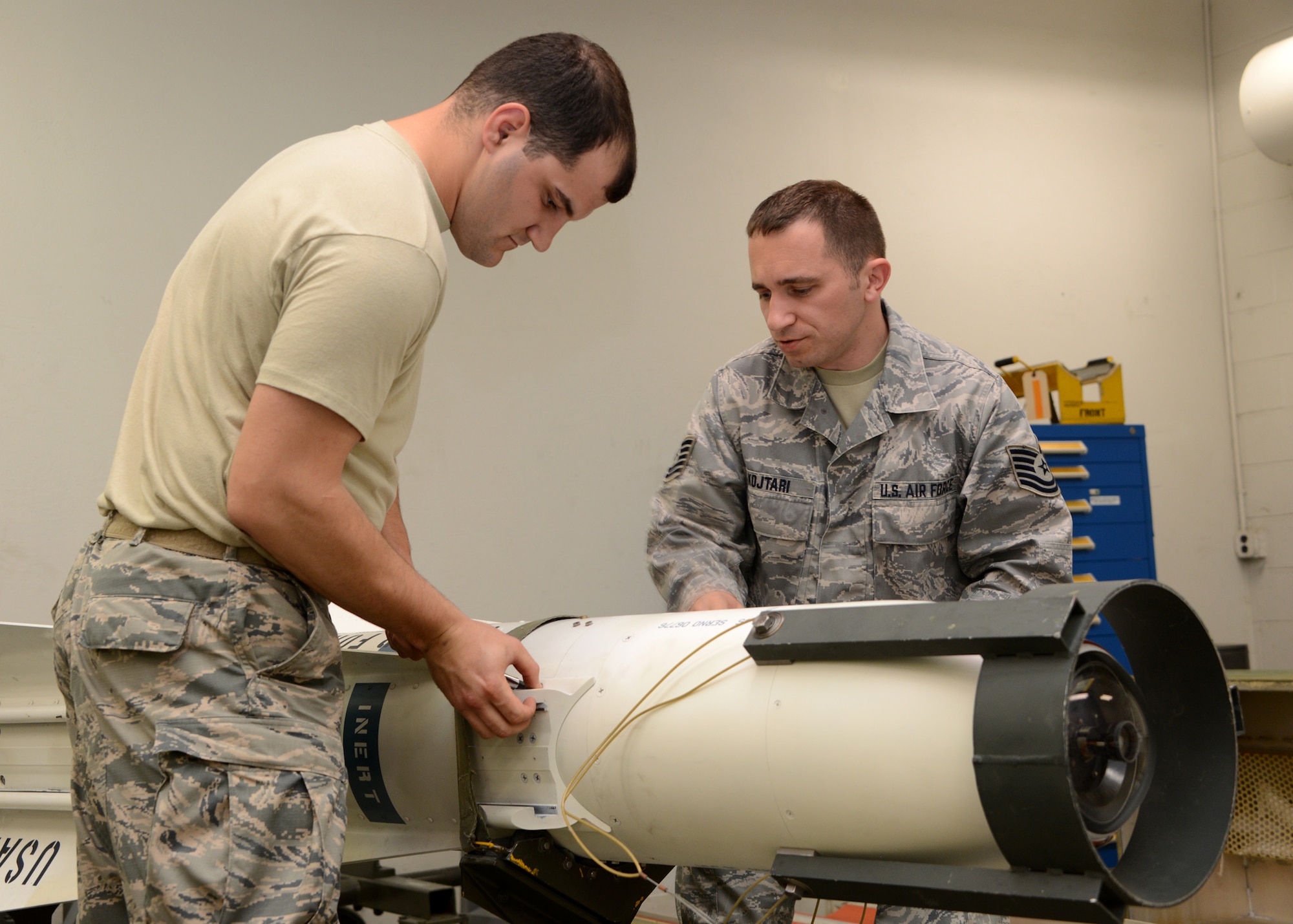 U.S. Air Force Tech. Sgt. Ilir Kojtari (right), 175th Maintenance Squadron precision guided munitions section non-commissioned officer in charge (NCOIC), 175th Wing Maryland Air National Guard, and U.S. Air Force Senior Airman Adam Ahern, 175th Maintenance Squadron munitions specialist, 175th Wing Maryland Air National Guard, attach a hoisting adapter to an AGM-65A missile maintenance trainer while preparing to remove the Guidance Control Unit (GCS) from the body of the missile.  Kojtari was training Ahern on the proper removal procedures for the Guidance Control Unit (GCS) of an AGM-65A missile.  (U.S. Air National Guard photo by Tech. Sgt. Christopher Schepers/RELEASED)