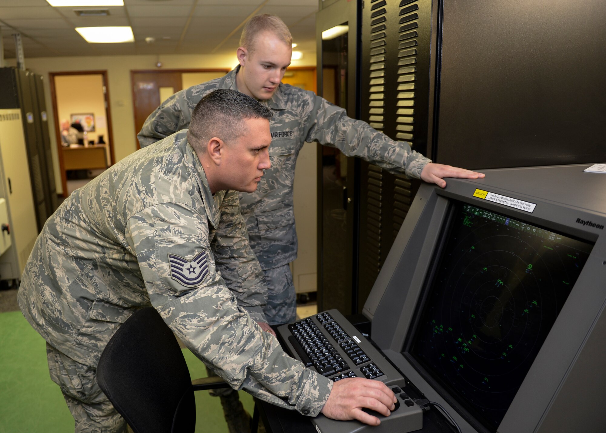 Tech. Sgt. Travis Miles, 48th Communications Squadron radar systems craftsman, and Airman 1st Class Christopher Ralston, 48th CS radar systems apprentice, monitor a digital airport surveillance radar at Royal Air Force Lakenheath, England, May 29, 2014. A DASR gives an aircraft location information while also providing a collision report. (U.S. Air Force photo by Airman 1st Class Nigel Sandridge/Released)