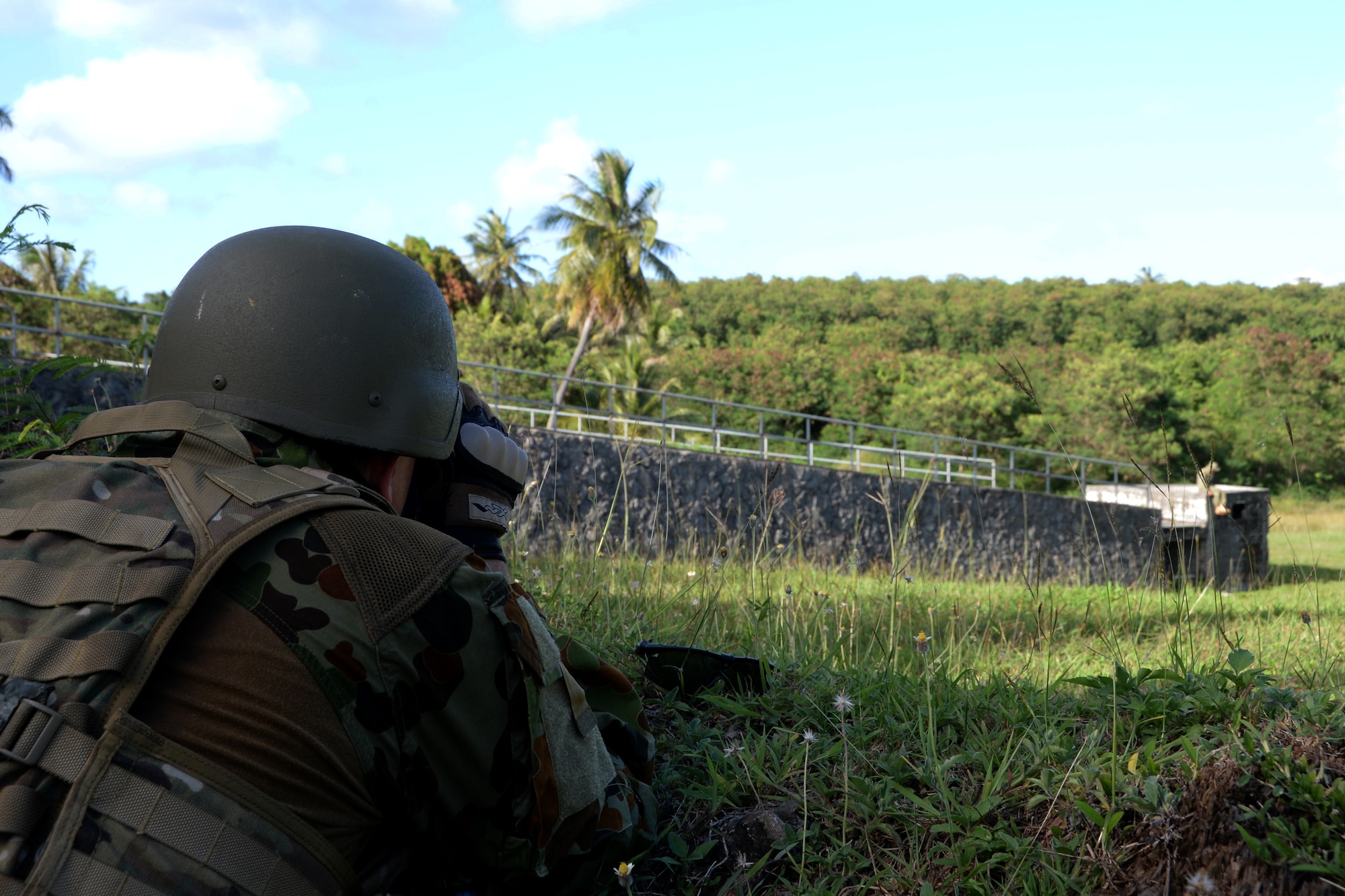 Royal Australian Air Force Flight Sergeant Dean Maher, One Security Forces Squadron Explosive Ordnance Disposal Flight senior NCO, looks at a training improvised explosive device through binoculars during Exercise Tri-Crab May 5, 2014, on Naval Base Guam. Tri-Crab is a biennial, multi-national EOD exercise designed to reinforce skillsets and strengthen interoperability among different countries. (U.S. Air Force photo by Airman 1st Class Amanda Morris/Released)