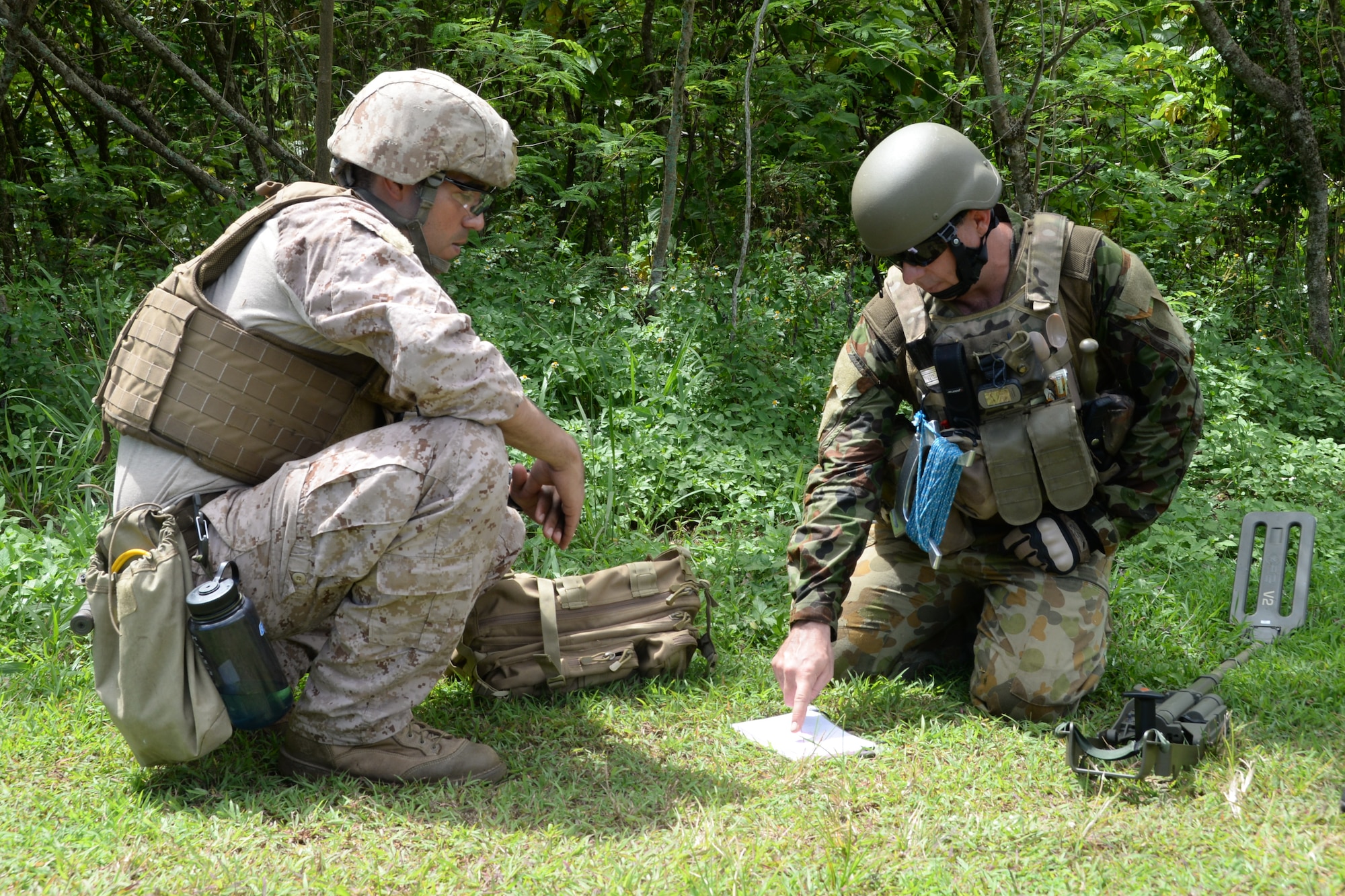 Explosive ordnance disposal technicians determine their plan of action before executing a training scenario for Exercise Tri-Crab May 5, 2014, on Naval Base Guam. Tri-Crab is a biennial, multi-national EOD exercise designed to reinforce skillsets and strengthen interoperability among different countries. (U.S. Air Force photo by Airman 1st Class Amanda Morris/Released)