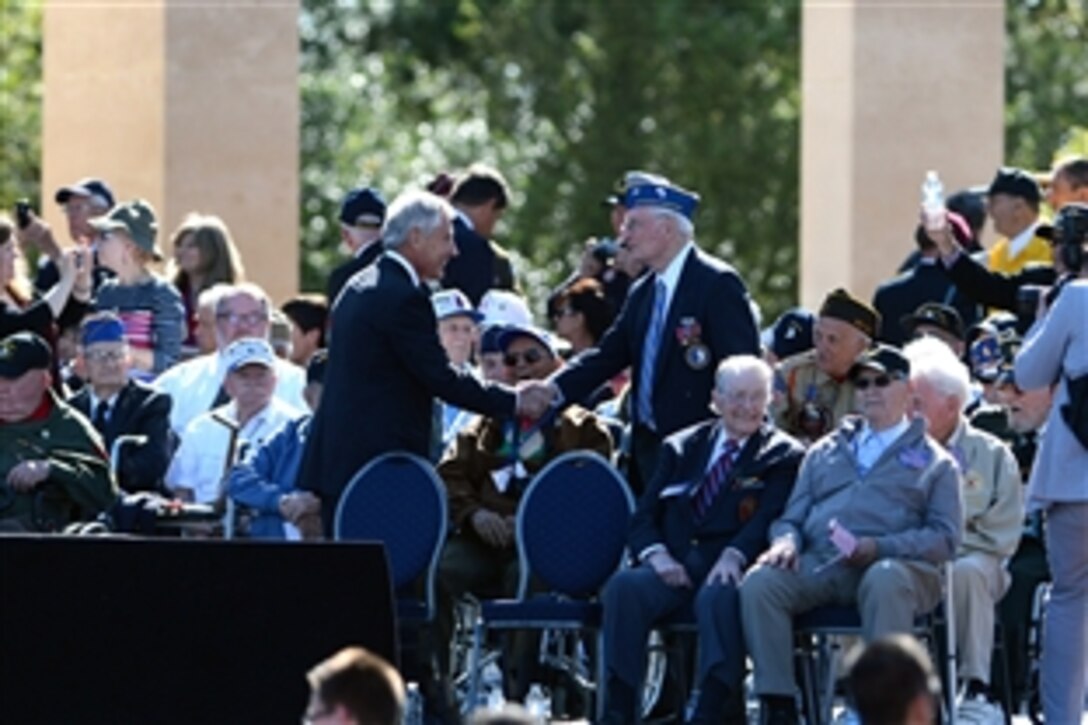 U.S. Defense Secretary Chuck Hagel, center left, greets and chats with a World War II veteran at the Normandy American Cemetery during the 70th Anniversary of D-Day in Normandy, France, June 6, 2014.