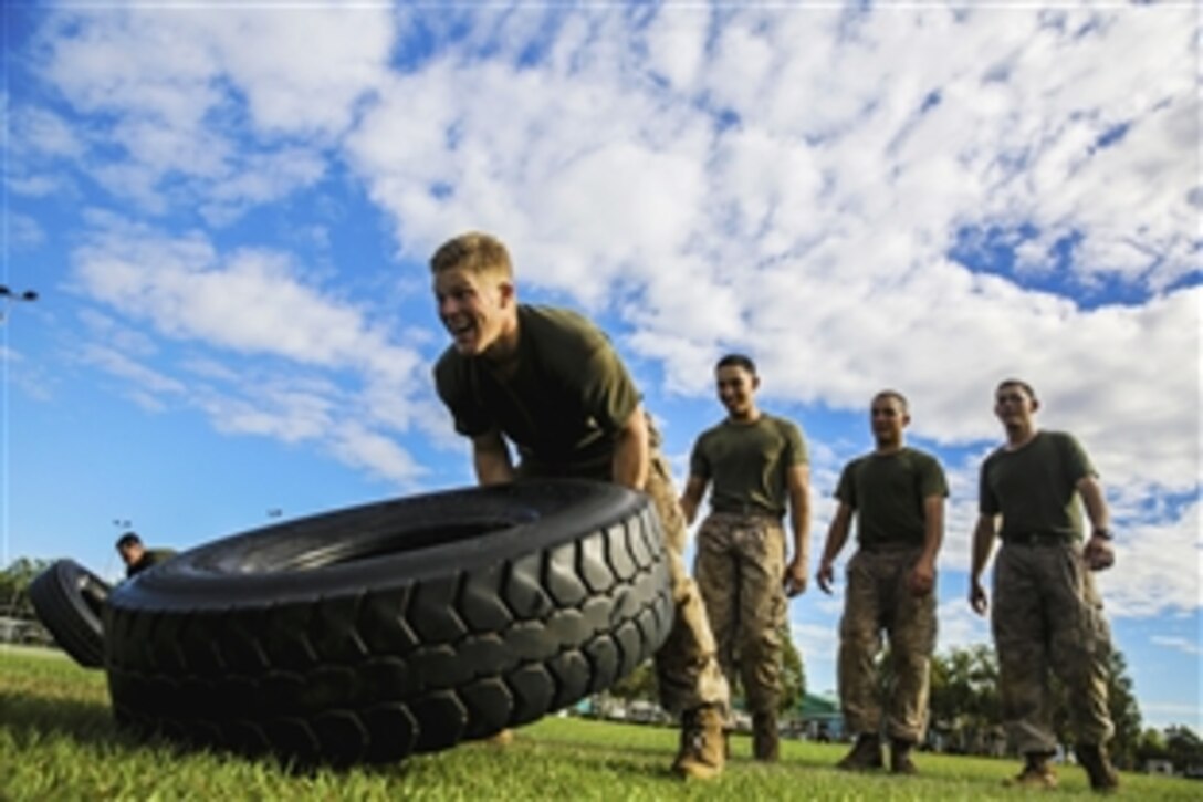 U.S. Marines flip tires during squad competition at Robertson Barracks, Northern Territory, Australia, June 4, 2014. Each squad was required to complete several infantry obstacles and events. The Marines are part of Charlie Company, 1st Battalion, 5th Marine Regiment, assigned to Marine Rotational Force-Darwin.