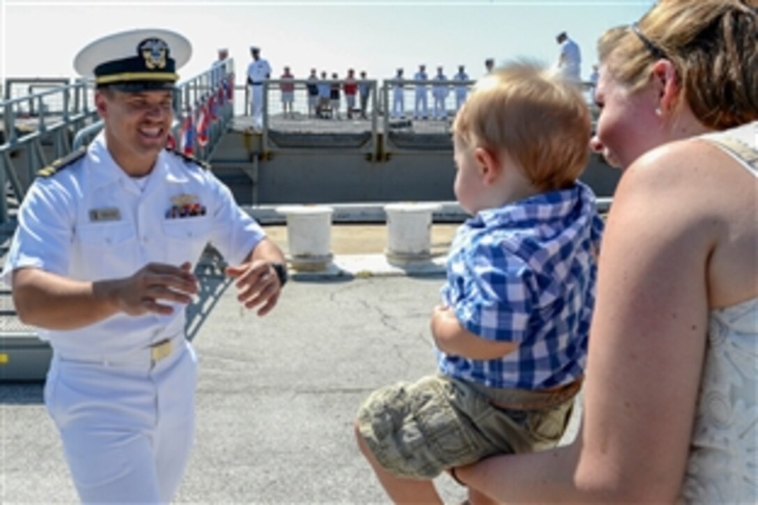 Navy Lt. j.g. Jeremiah Derrick reaches for his son for the traditional first hug upon his return to Naval Station Mayport, Fla., June 4, 2014, following a five-month deployment aboard the USS Halyburton,  The Halyburton is scheduled to be decommissioned later this year after more than 30 years of service.  